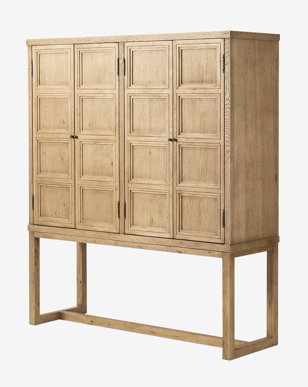 The Carrington Cabinet features four paneled doors, a rectangular base, and simple bronze-finished hardware in a light worn oak finish for an elegant, timeless look, by McGee & Co.