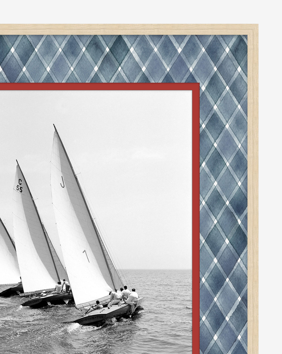 “Chasing the Wind” is a black-and-white giclée print featuring three sailboats racing on calm water, set against blue plaid with a red border in a light wood frame—ideal for coastal décor, by McGee & Co.