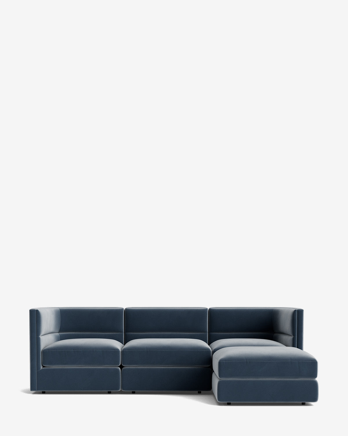 The Claremont Modular Sofa with Ottoman 99 is a modern dark blue three-seater with a channeled back and right-side chaise lounge, shown against a plain white background by McGee & Co.