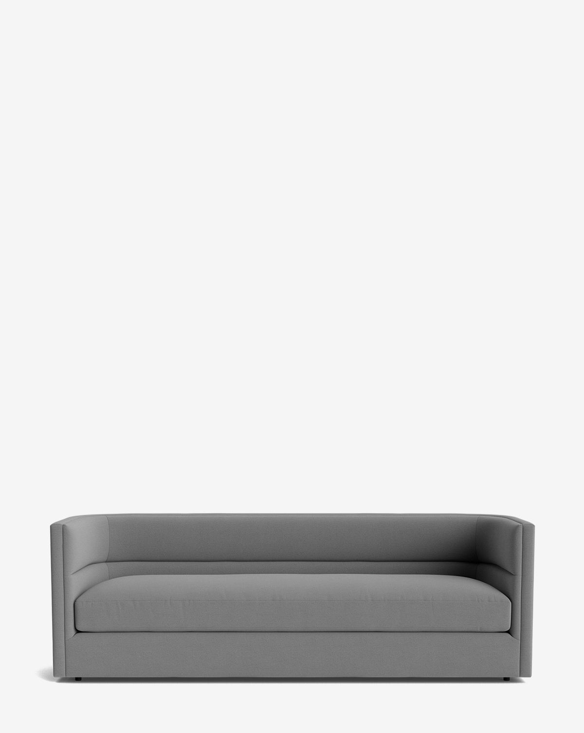 The Claremont Sofa 84 is a modern gray upholstered piece with a low back, straight lines, and minimalist design in high-quality fabric, shown against a plain white background by McGee & Co.