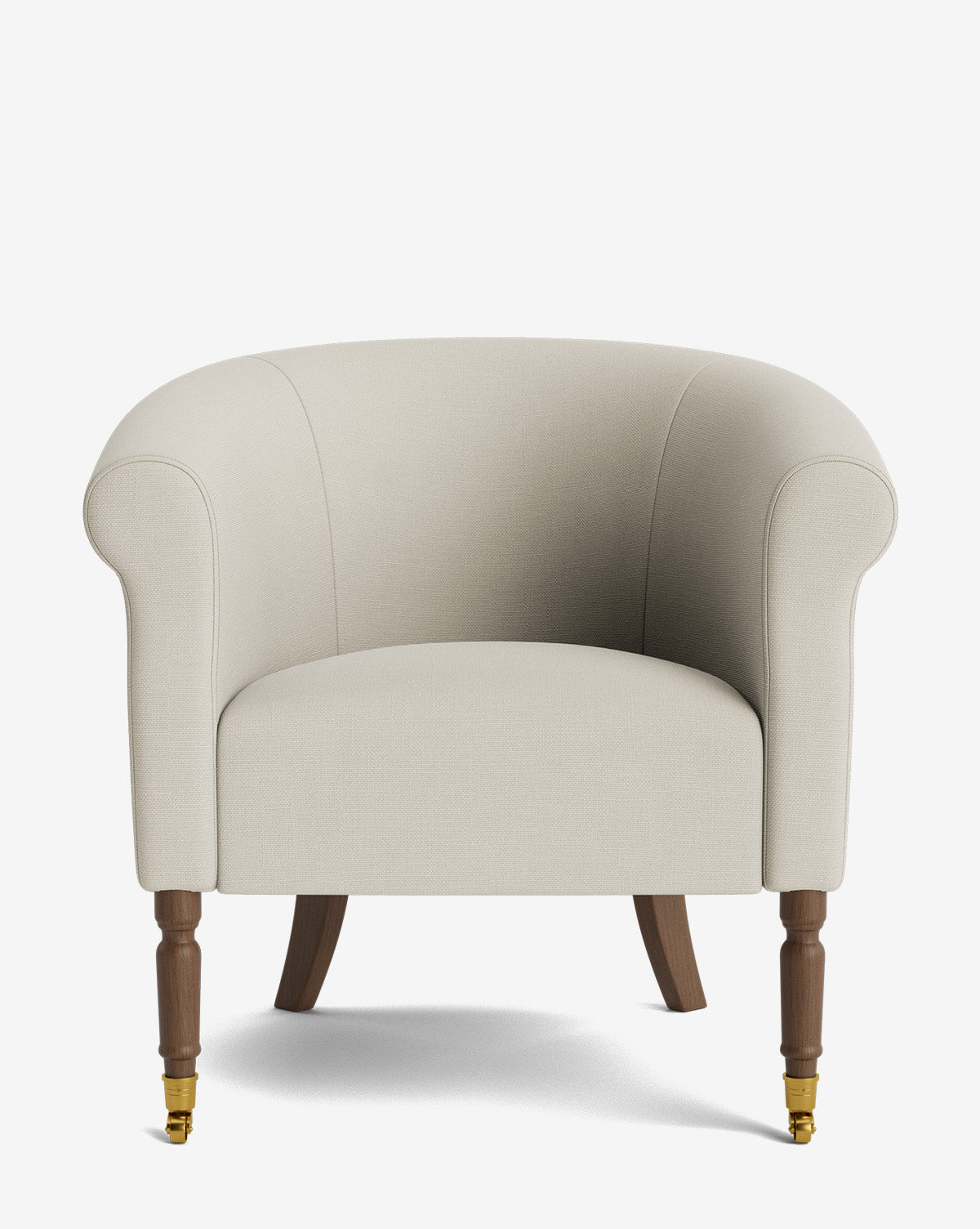 The Clemence Lounge Chair features beige upholstery, curved arms, wooden legs with brass castor wheels on the front, and adds timeless style to any space. Set against a white background, this classic living room chair enhances any decor by McGee & Co.