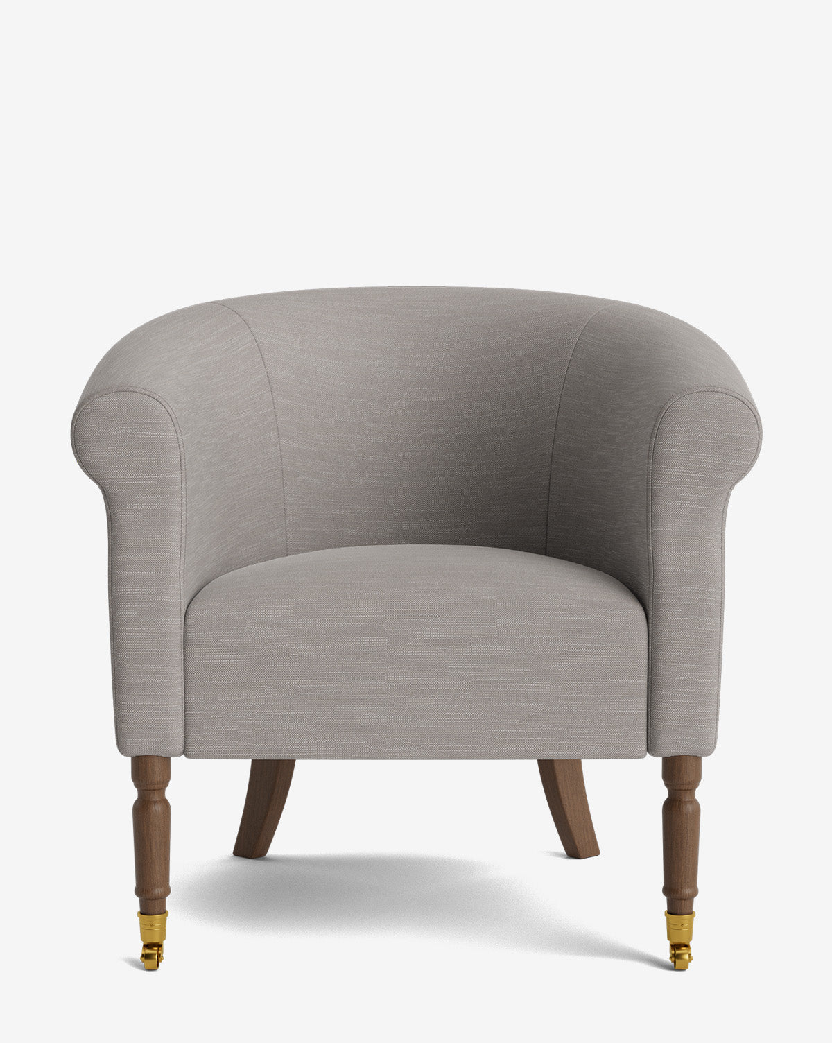 The Clemence Lounge Chair features light grey designer fabric, a curved backrest, rounded arms, and four wooden legs—front two with brass casters and rear two tapered—making it a stylish choice for any living room, by McGee & Co.