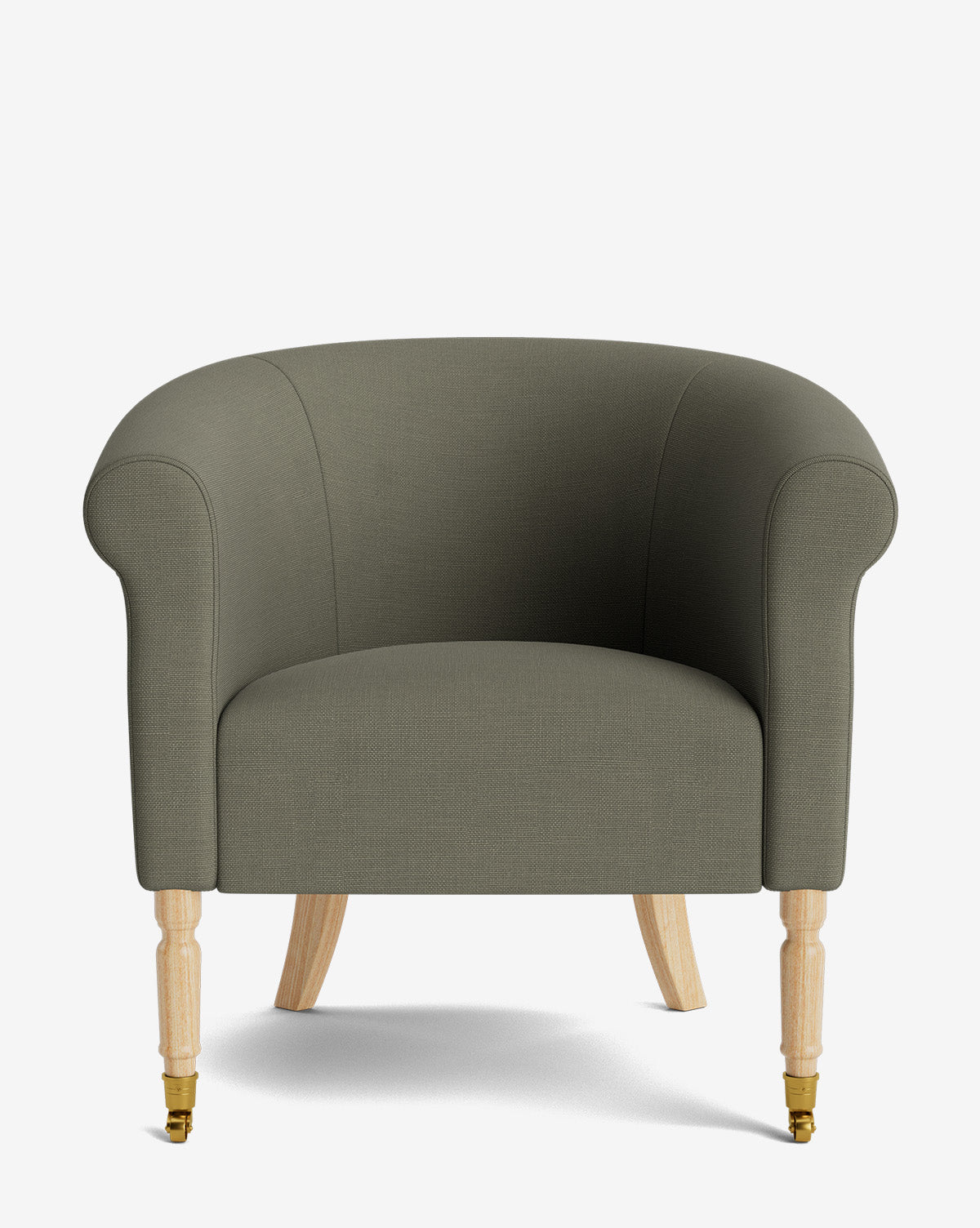 The Clemence Lounge Chair is a modern, olive-green upholstered piece with rounded arms and wooden legs—two with brass caster wheels, by McGee & Co. Shown in designer fabric, this classic chair stands out against a plain white background.