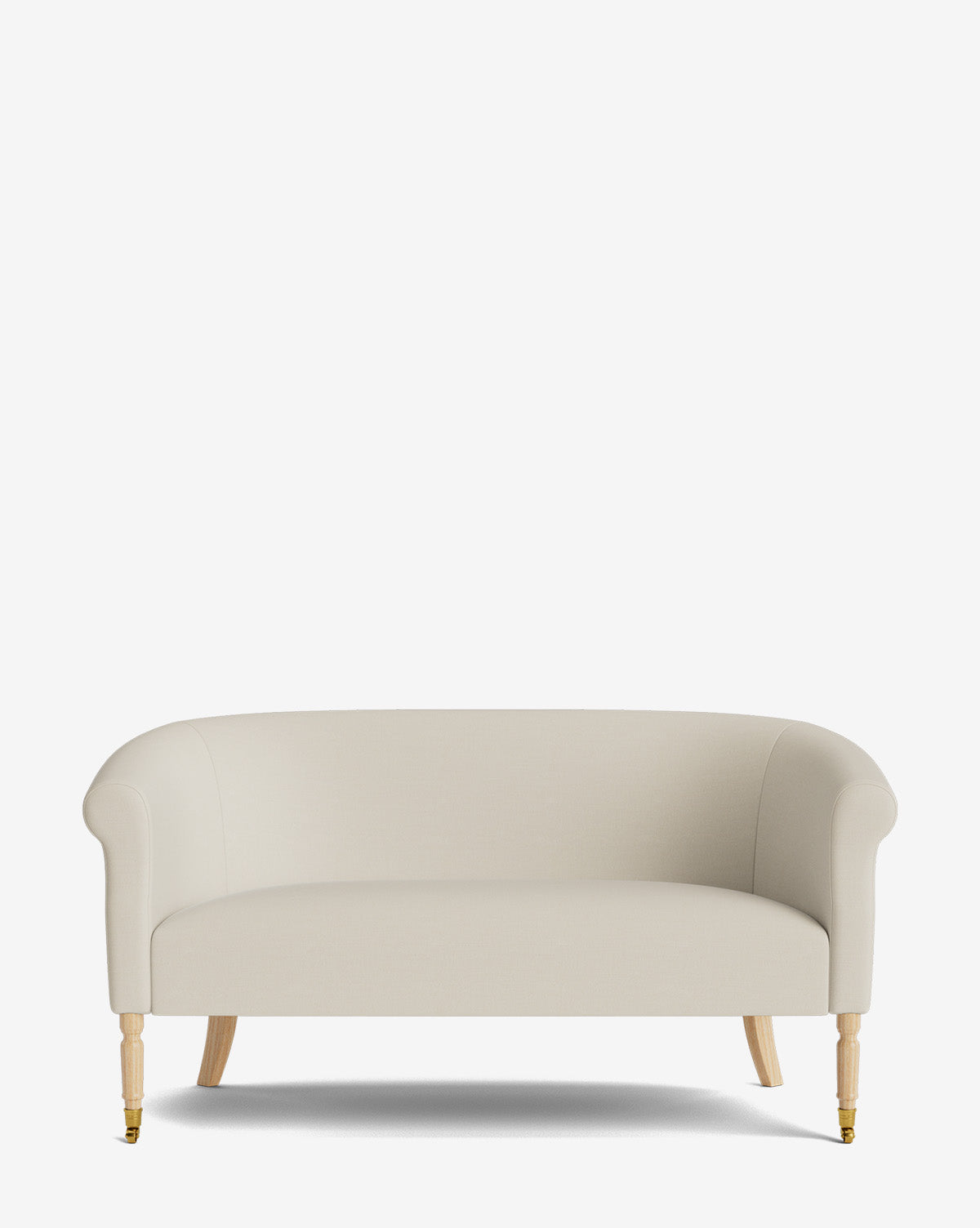 The Clemence Settee 60 features cream-colored designer fabric upholstery, curved armrests, and light wooden legs, by McGee & Co. Against a plain white background, its front left leg is accented with a brass caster for added elegance.