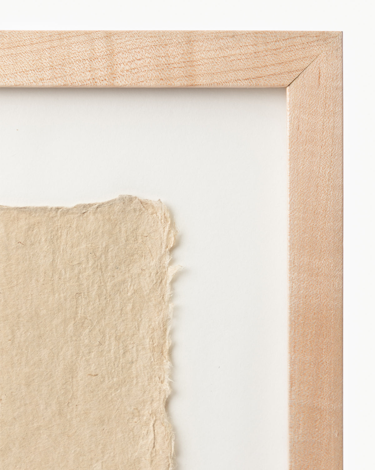 A close-up of the top right corner of Collage 1 shows textured, torn-edged handmade paper art in a maple wood frame against a white background. Only part of this neutral wall art and paper are visible.