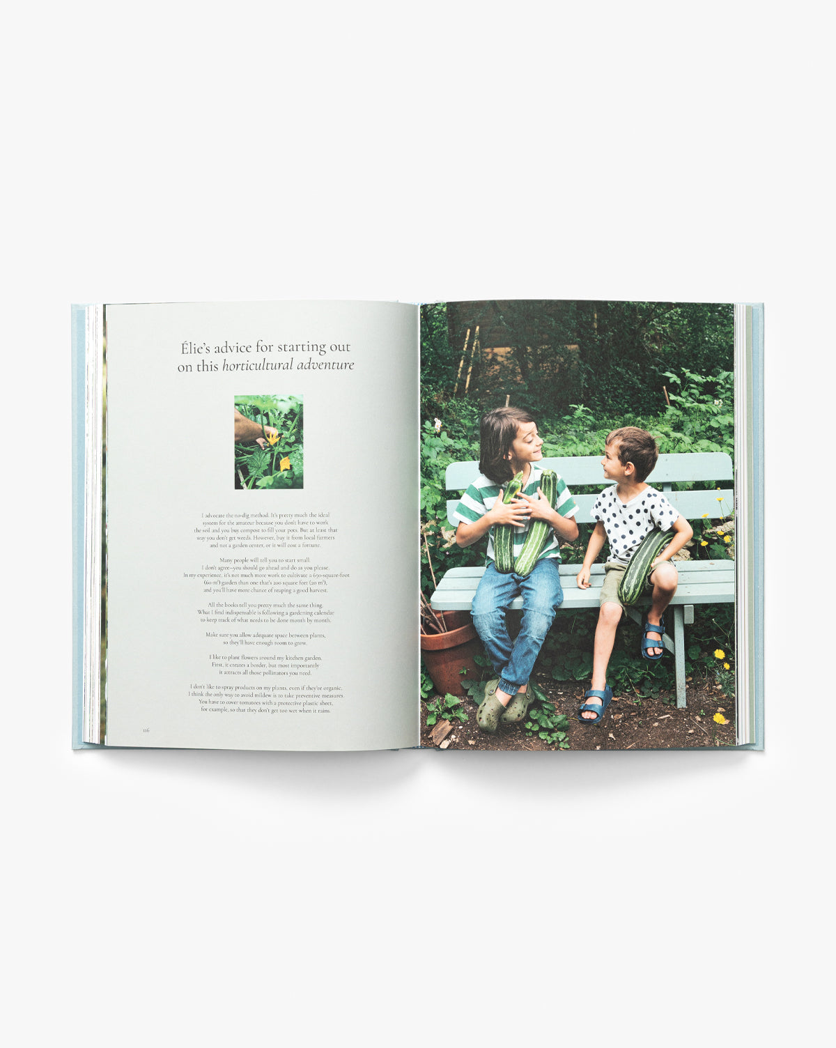 The open book, Coming Home to Nature: The French Art of Countryfication, displays a photo of two children on a garden bench, smiling. The left page shows text and a small image of a child gardening among lush plants. Perfect for any coffee table collection, by McGee & Co.