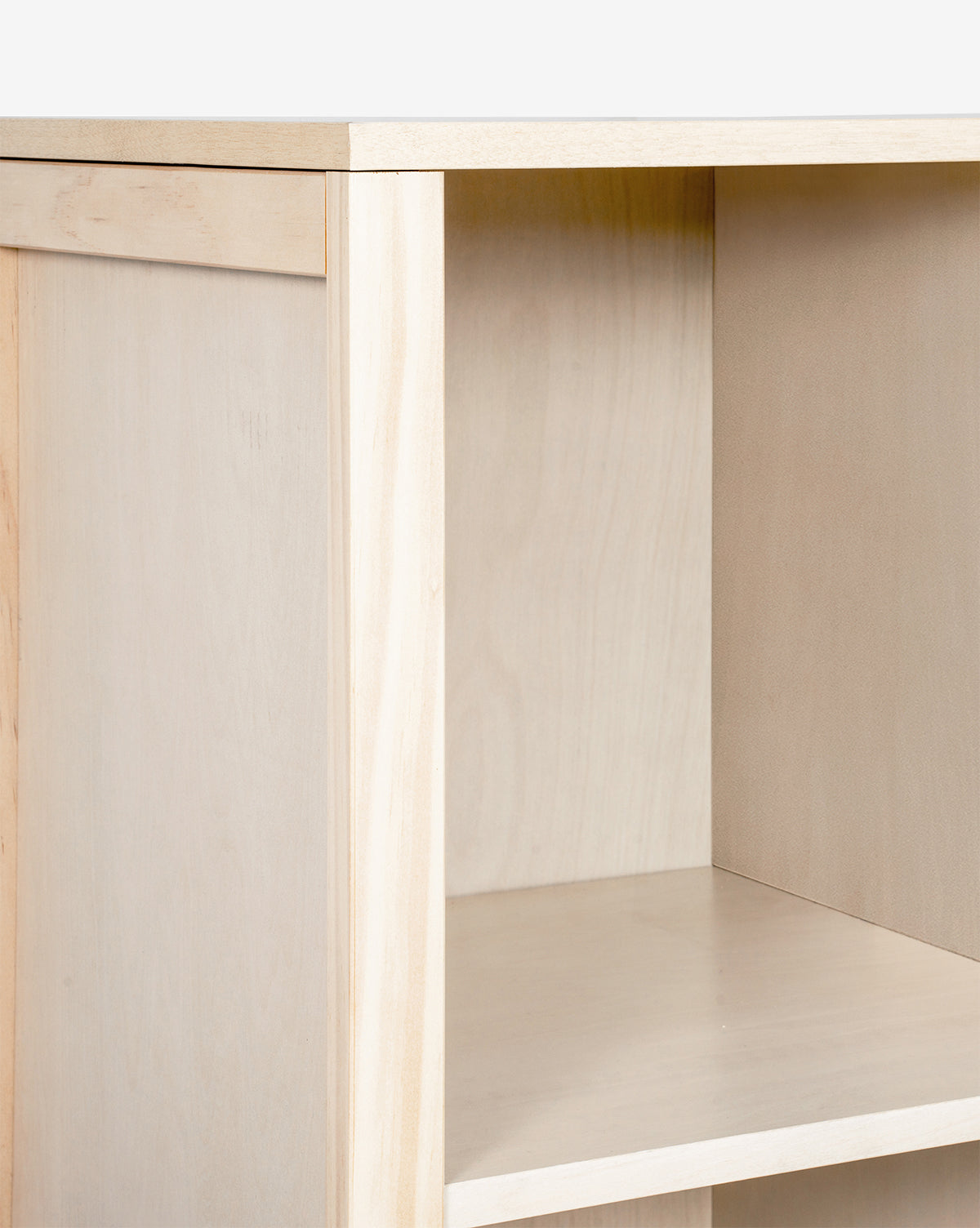 Close-up of the Hudson Bookcase, empty and light-colored, crafted from sustainable New Zealand pine wood. It features simple, clean lines and a smooth finish, set against a plain white background by McGee & Co.