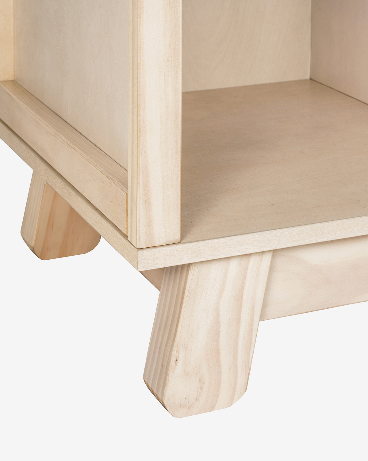Close-up of the Hudson Bookcases bottom corner, featuring a square base and angled legs with a smooth natural finish, all crafted from sustainable New Zealand pine wood, by McGee & Co.