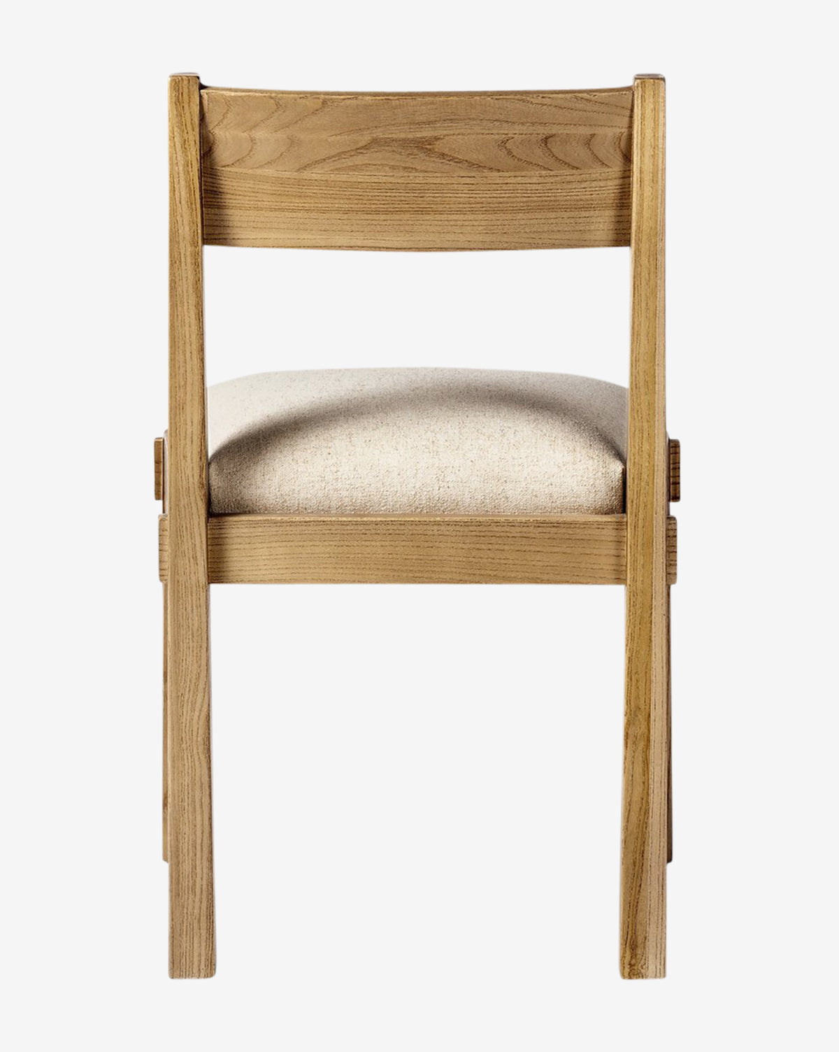 The Cyprian Dining Chair showcases a simple design with a light wood frame and padded beige performance fabric seat, viewed from the back on a white background—ideal for any dining space, by McGee & Co.