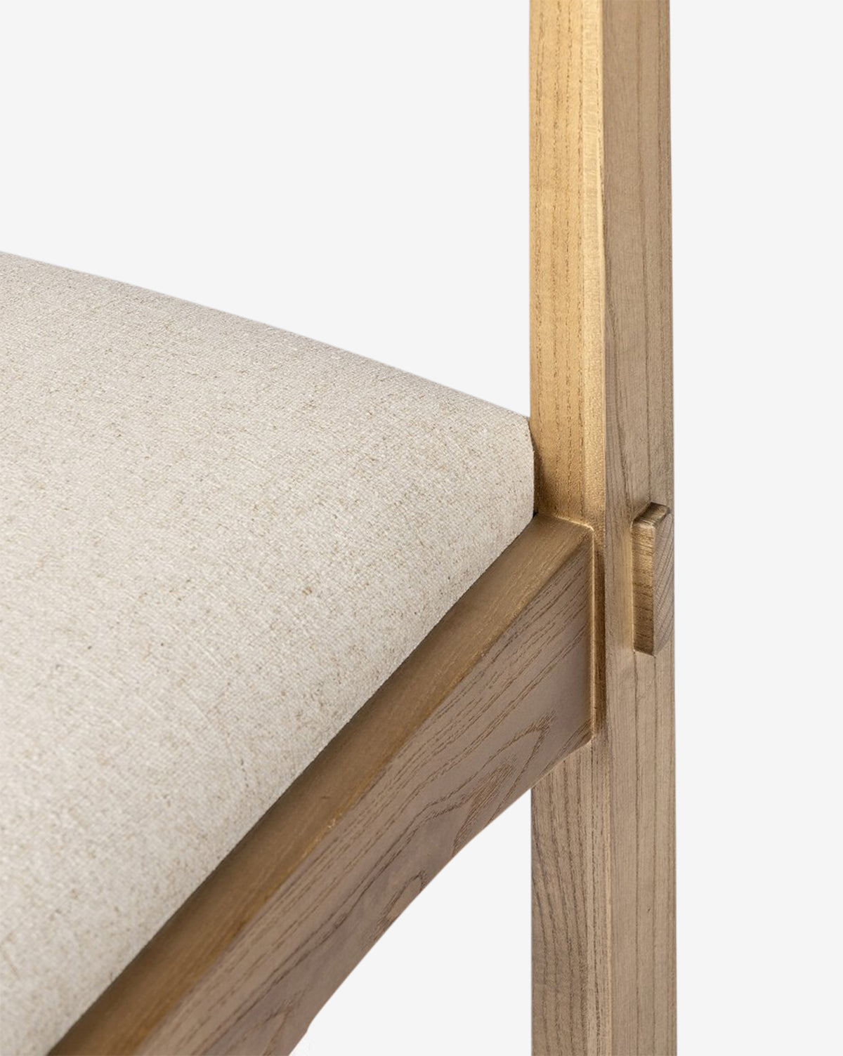 The Cyprian Dining Chair showcases a light beige performance fabric cushioned seat and a natural wood frame, emphasizing its joinery and texture—making it an ideal addition to any dining room, by McGee & Co.