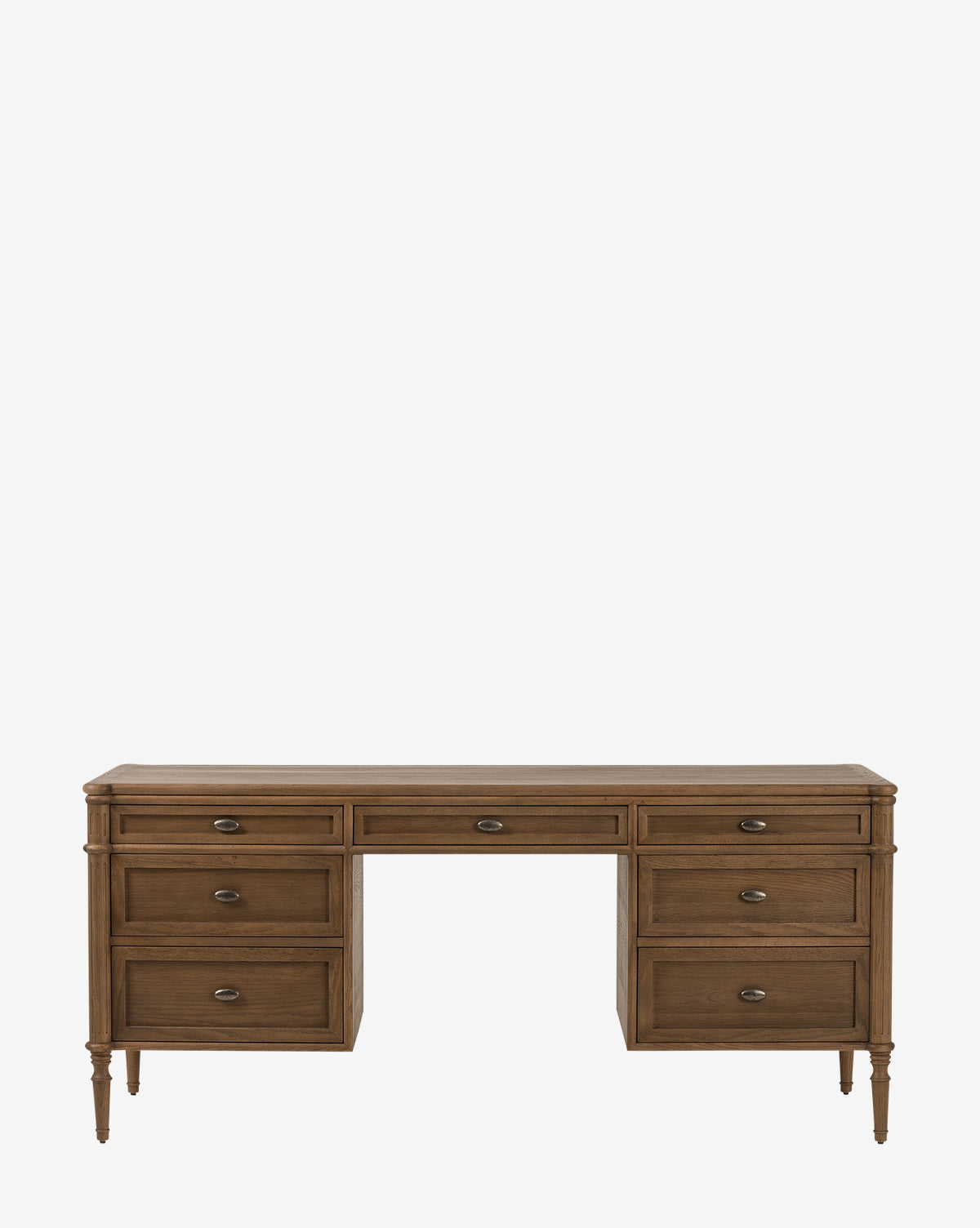 The Dixon Desk is a classic oak desk with a natural finish, seven drawers (three per side and one center), turned legs, and metal handles for a timeless office look, by McGee & Co.