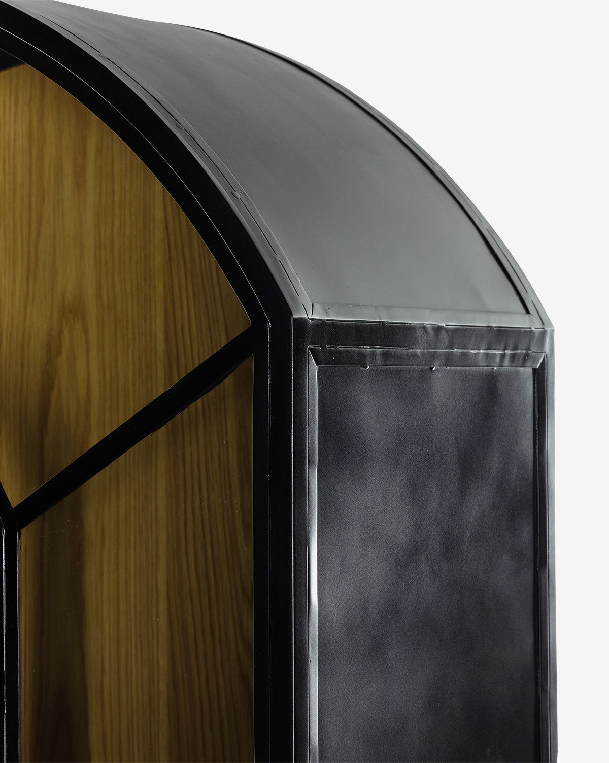 Close-up of the Darcie Cabinet’s top corner, featuring a curved matte black metal frame and wood paneling. Its clean lines and bold contrasts make this modern display cabinet a standout piece for contemporary decor.