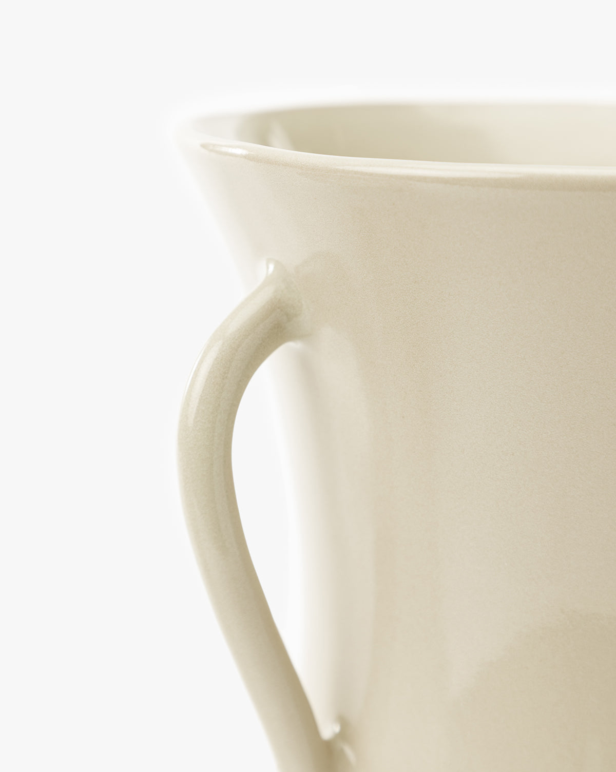Close-up of the Delphine Footed Vase in beige ceramic, highlighting part of the handle and rim against a plain white background, by McGee & Co.