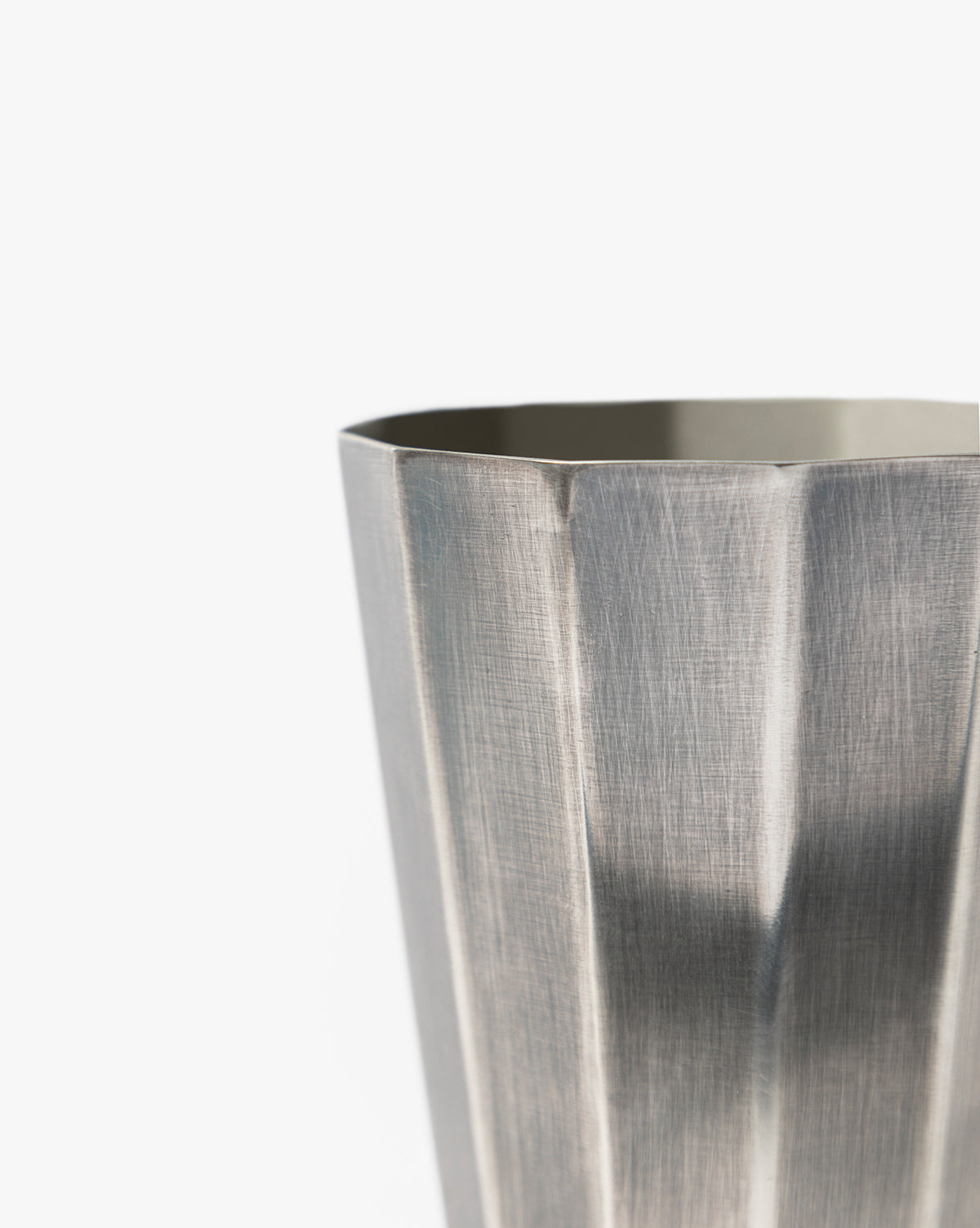 A close-up of the Derby Vase, a metallic, faceted tumbler with a brushed texture, ideal for flower arrangements and displayed against a plain white background, by McGee & Co.
