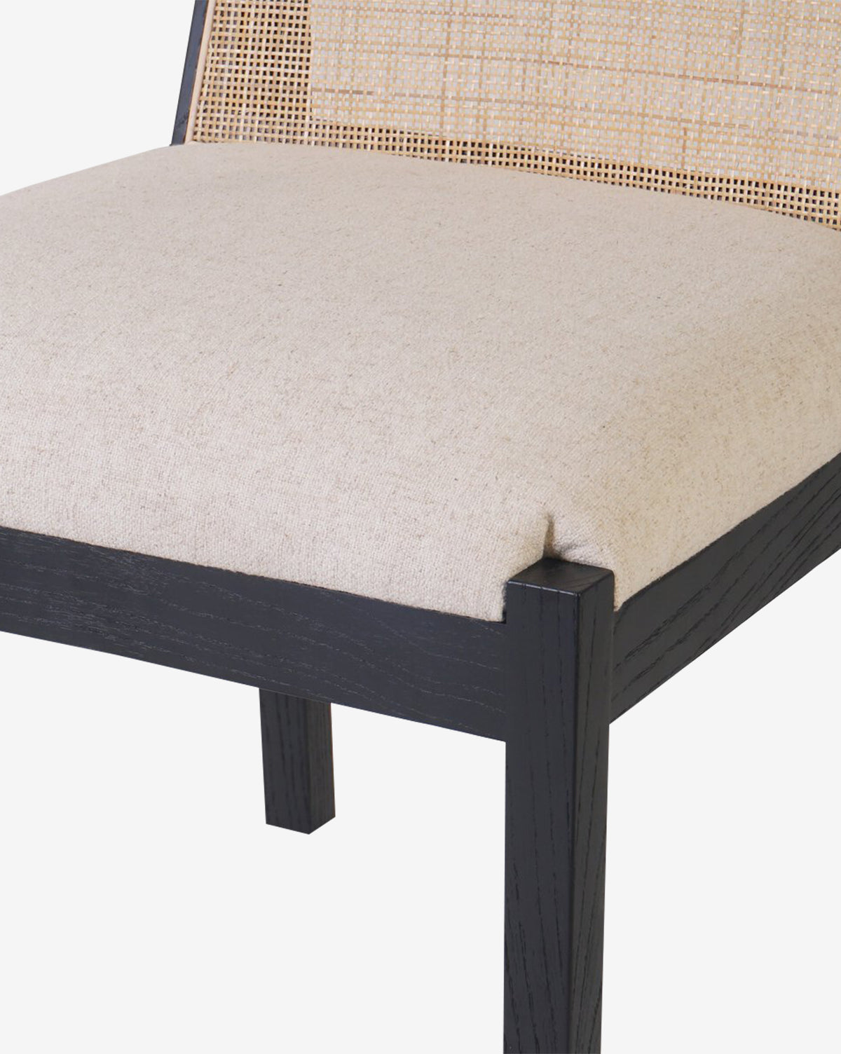 A close-up of the Eira Dining Chair shows its performance fabric seat, cane back, and black wooden frame against a plain white background, by McGee & Co.