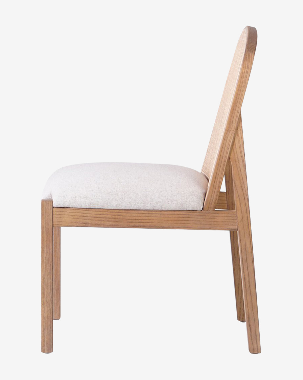 Side view of the Eira Dining Chair, showcasing its cushioned backrest and light performance fabric seat. Featuring a minimalist design with clean lines, natural wood finish, and timeless style by McGee & Co.