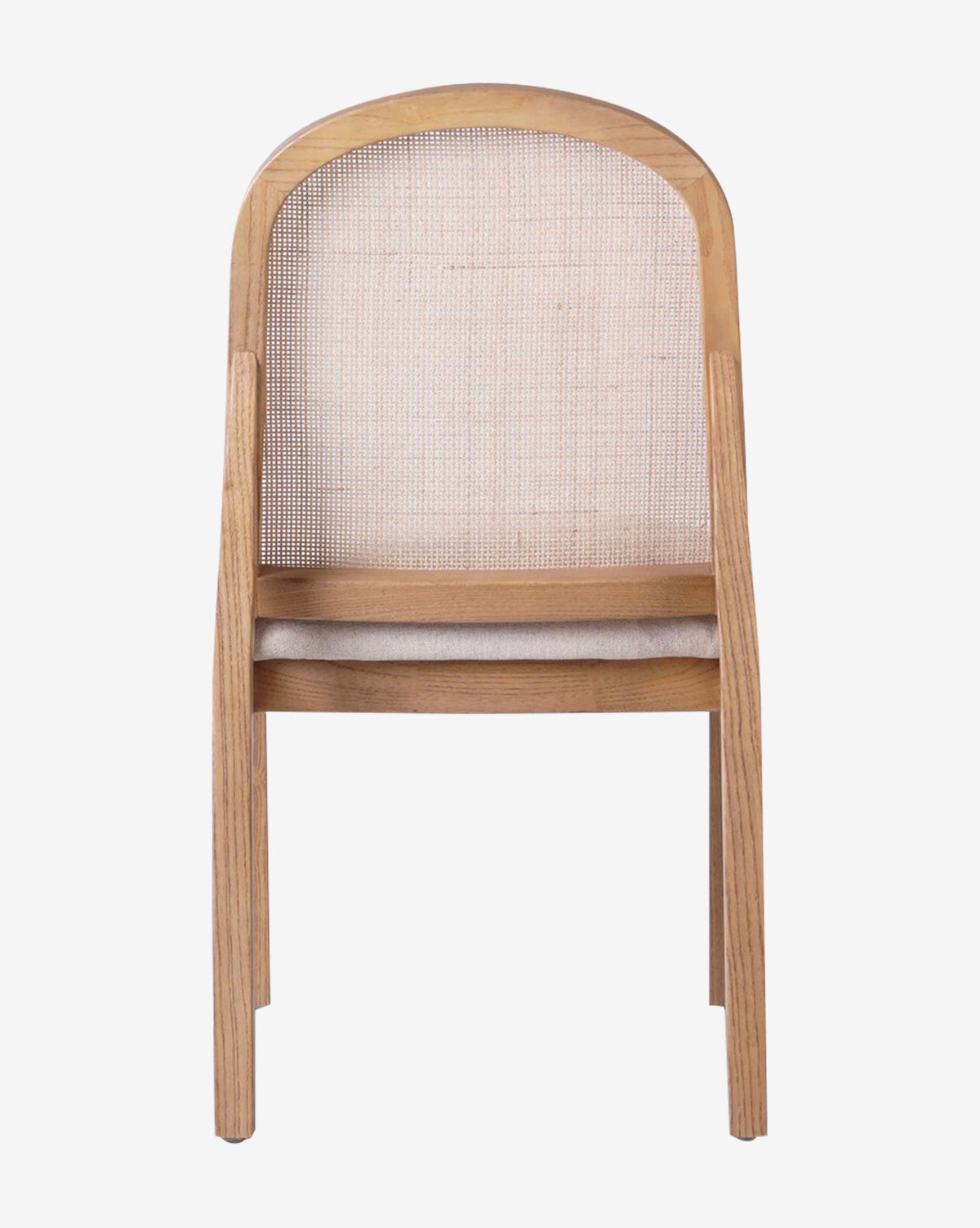 The Eira Dining Chair is shown from behind against a plain white background, highlighting its wooden frame, curved backrest, light beige performance fabric seat, and cane back panel by McGee & Co.