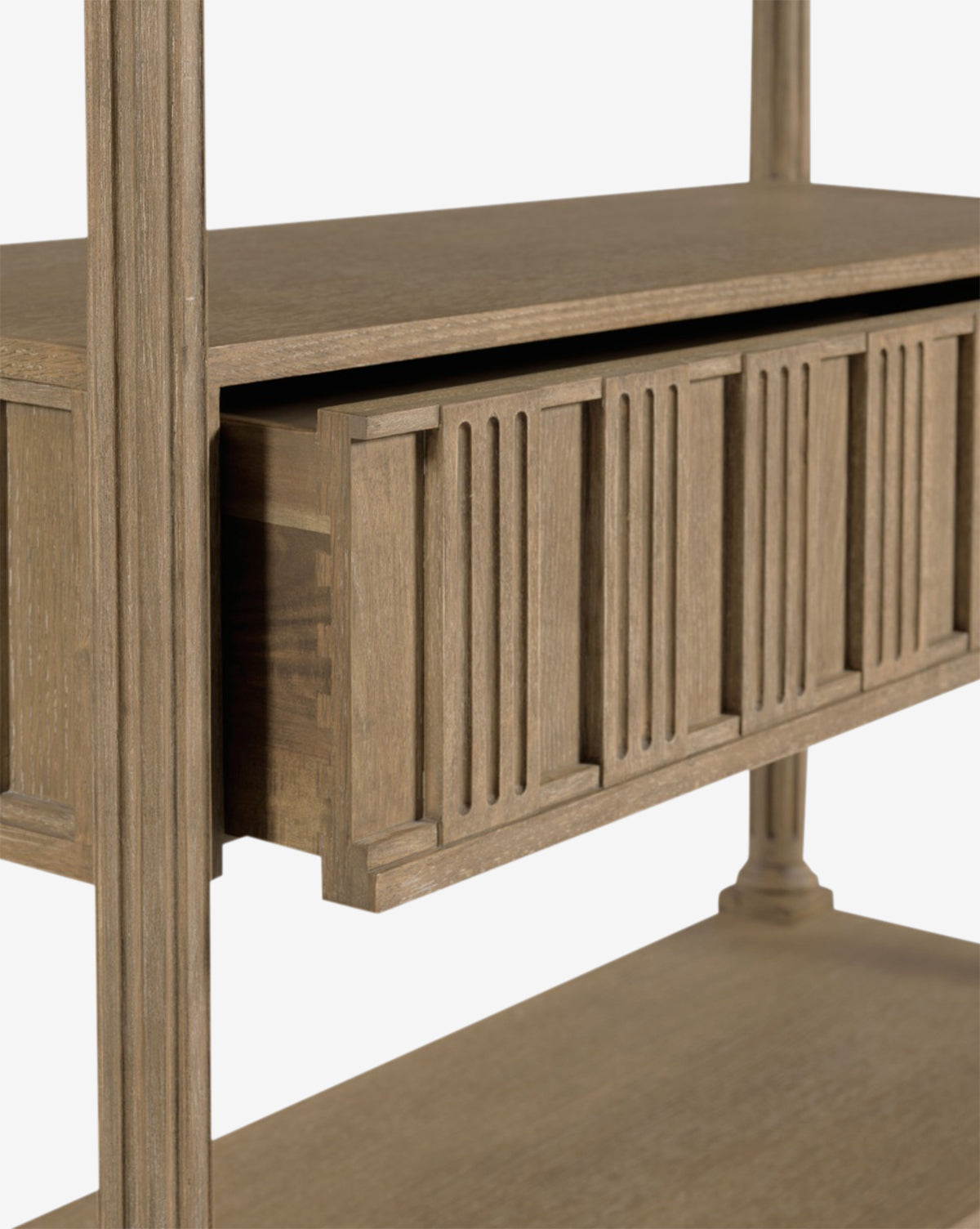 Close-up of the Elena Bookcase—a wooden cabinet with a partially open drawer, vertical groove detailing on the front, and a natural oak veneer finish over sturdy hardwood solids, by McGee & Co.