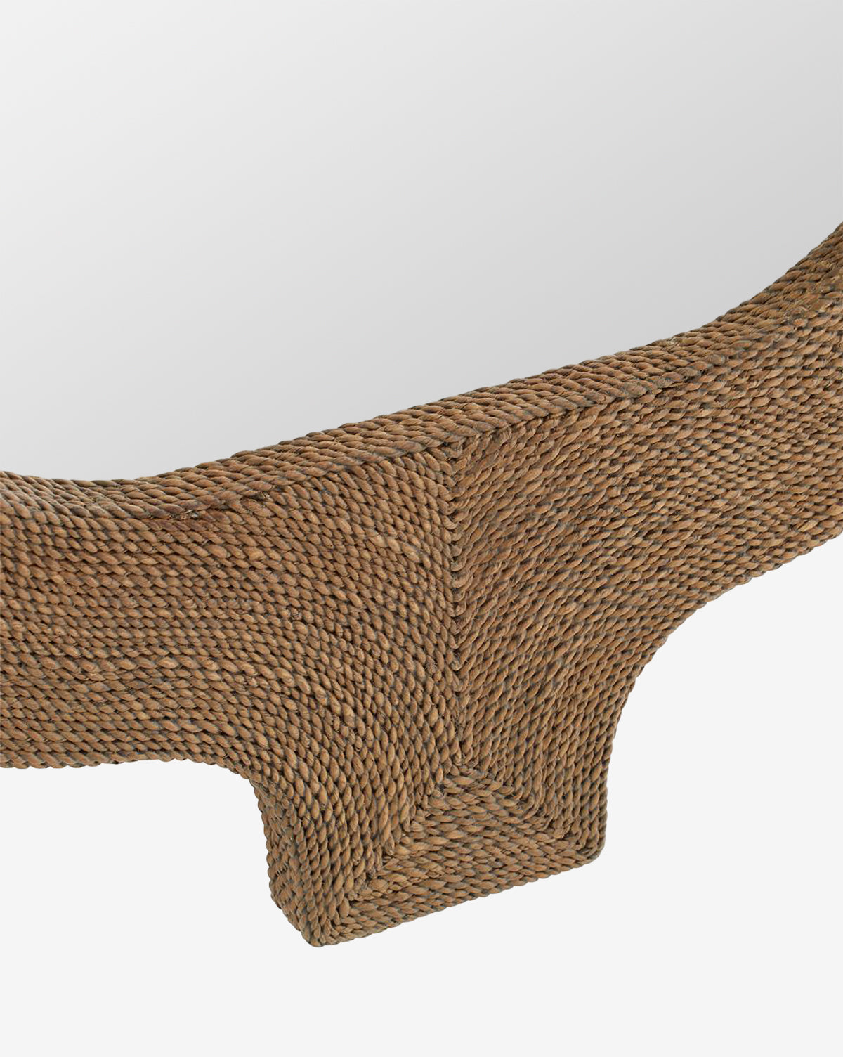 Close-up of the Elysia Mirror, showcasing its thick, textured rattan frame in natural brown with abaca rope accents and a curved design inspired by Indian architecture, all set against a white background, by McGee & Co.