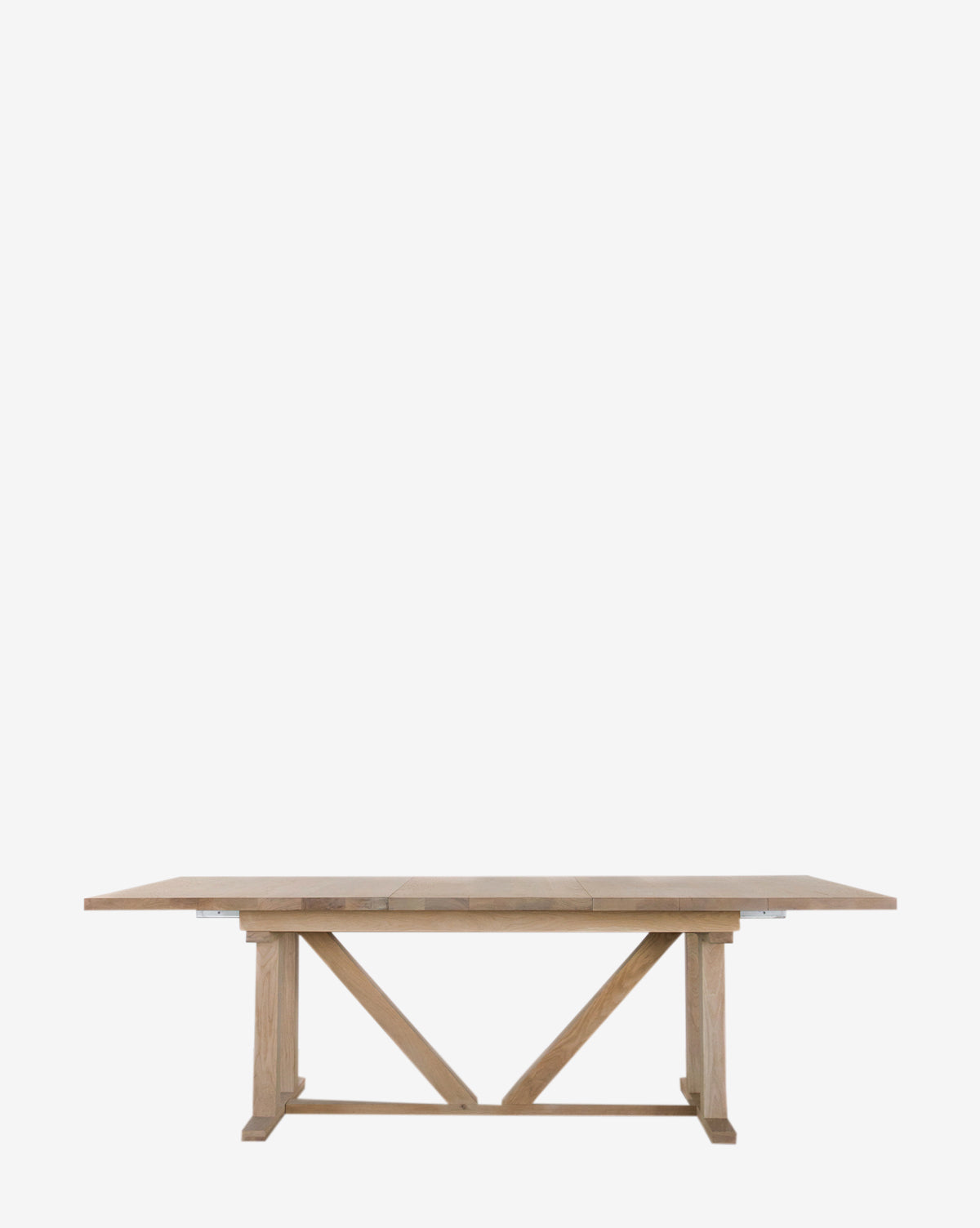 The Emory Extension Dining Table is a large rectangular solid oak piece featuring a sturdy architectural trestle base with angled supports, shown against a plain white background by McGee & Co.