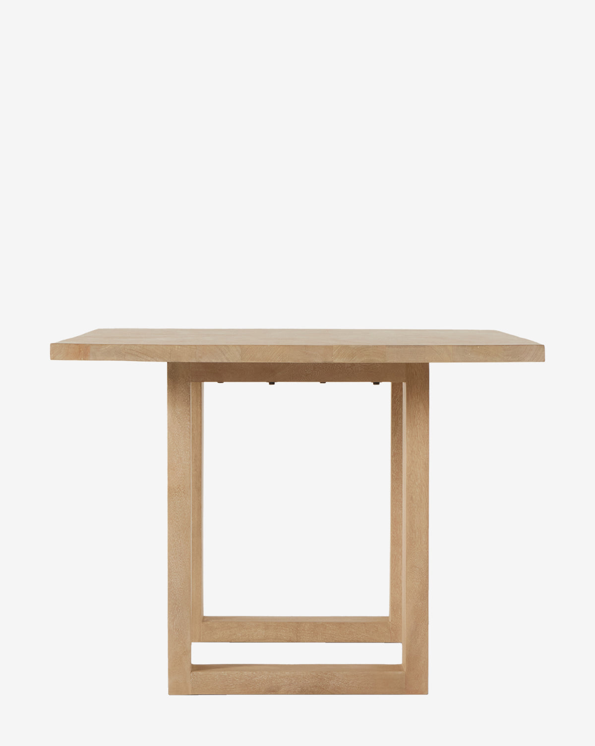 The Ernie Dining Table showcases a thick solid mango wood top and a geometric square base, creating a bold modern statement against a plain white background by McGee & Co.