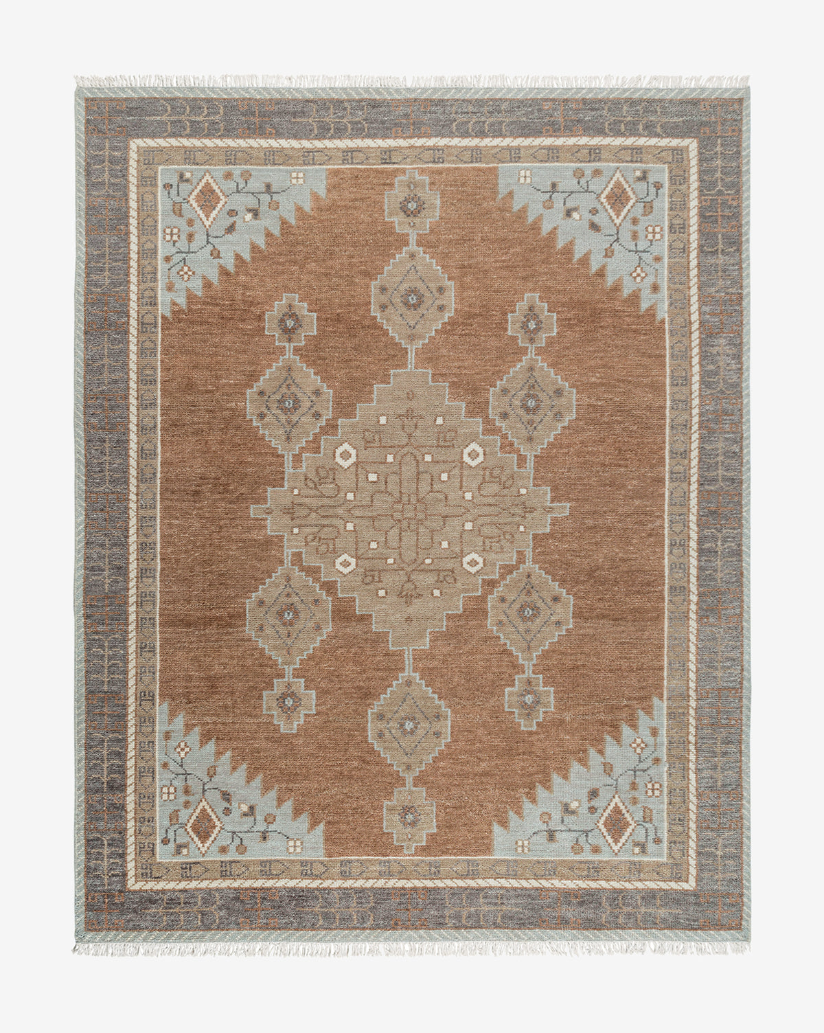 The Estrella Hand-Knotted Wool Rug features a rectangular shape, brown background, central geometric medallion, symmetrical beige, gray, and light blue patterns, a traditional-inspired decorative border, and short fringe edges by McGee & Co.