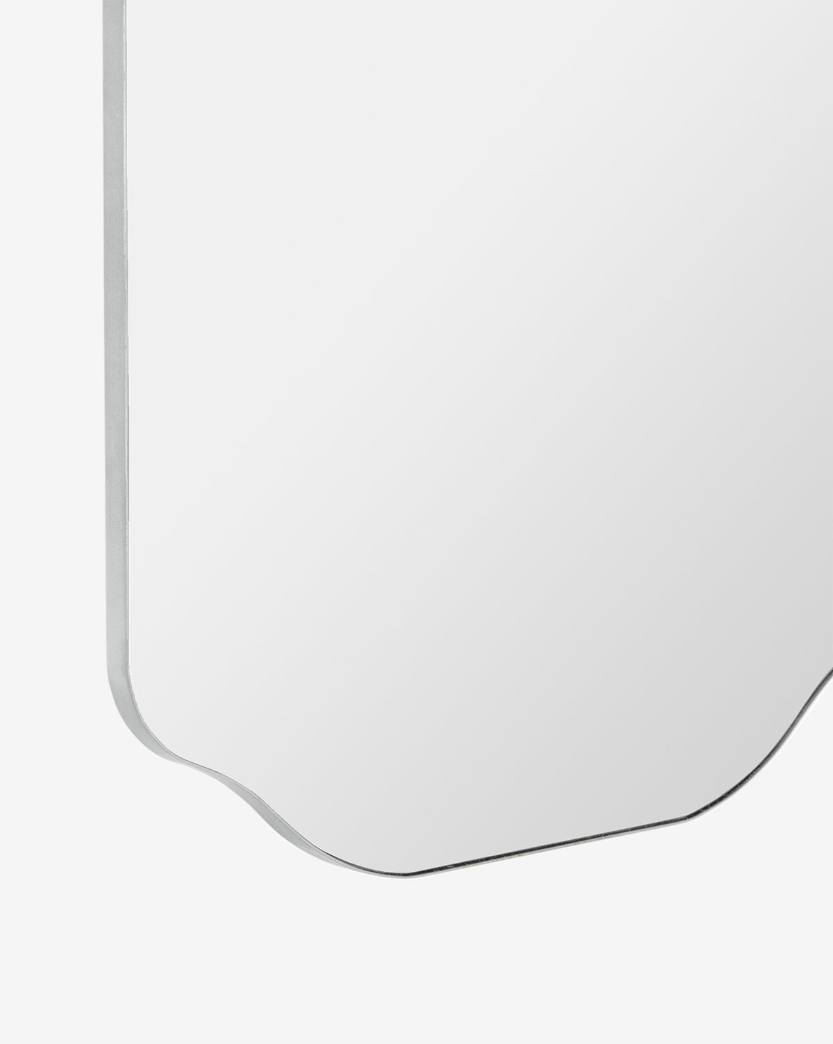 A close-up of the corner of the Ethel Wall Mirror, featuring a beveled edge against a white background, by McGee & Co.