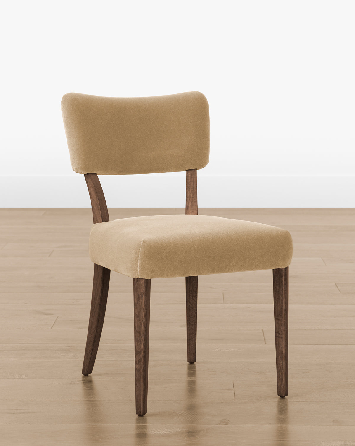 The Etienne Dining Chair (Ready to Ship) showcases a beige upholstered seat, curved backrest, and wooden legs for a timeless look—perfectly suited for placement on light wood floors with a clean white wall backdrop, by McGee & Co.