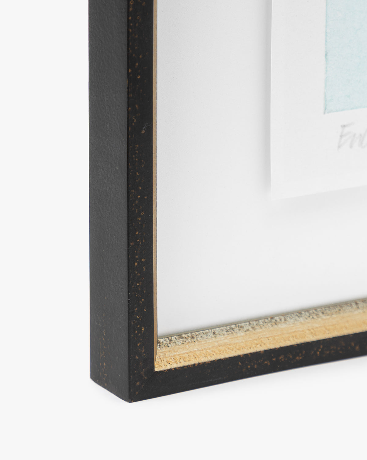 Close-up of a distressed black and gold frame with a gold inner edge, showcasing Eucalyptus Windows, a matted giclee print in light blue and white against a white background.
