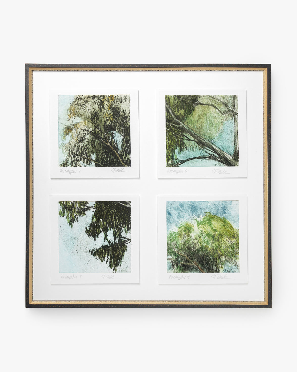 Eucalyptus Windows features four impressionistic giclee prints of green and blue tree branches, labeled and arranged in a grid on a white mat with a distressed black and gold frame.