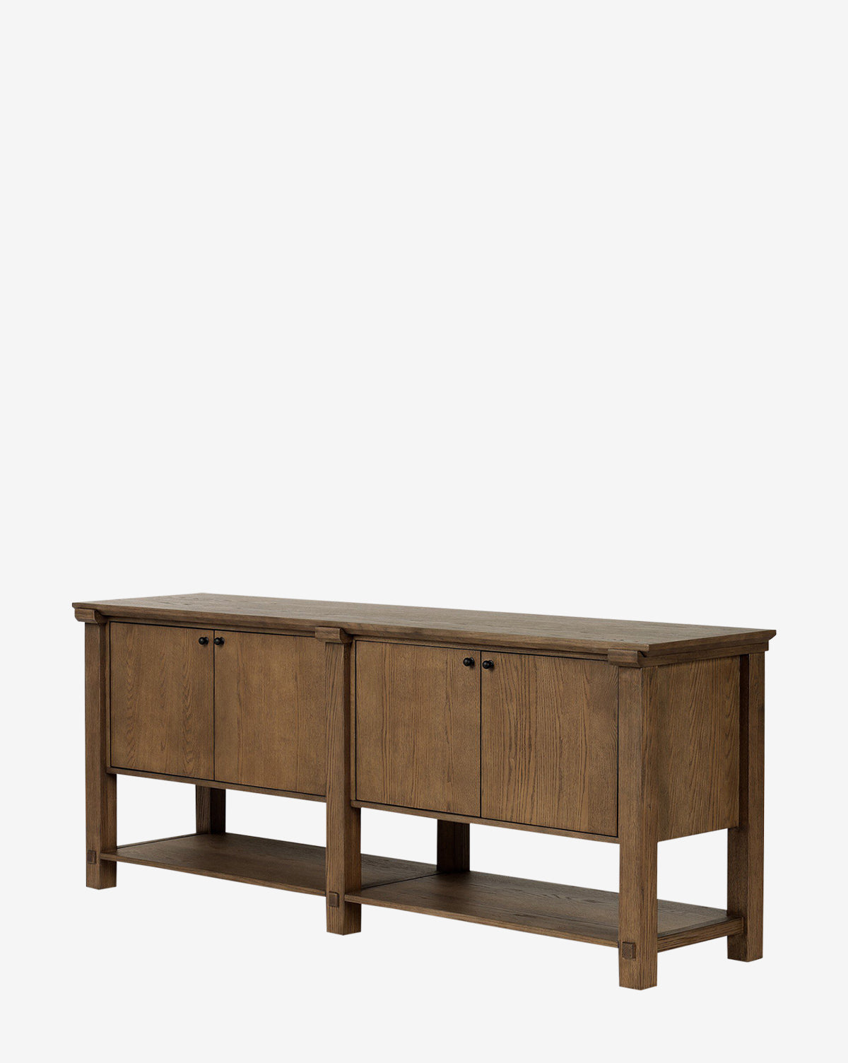 The Evaline Sideboard is a rectangular solid oak piece in a natural finish, with two double-door cabinets featuring black iron hardware and an open lower shelf, shown against a plain white background by McGee & Co.