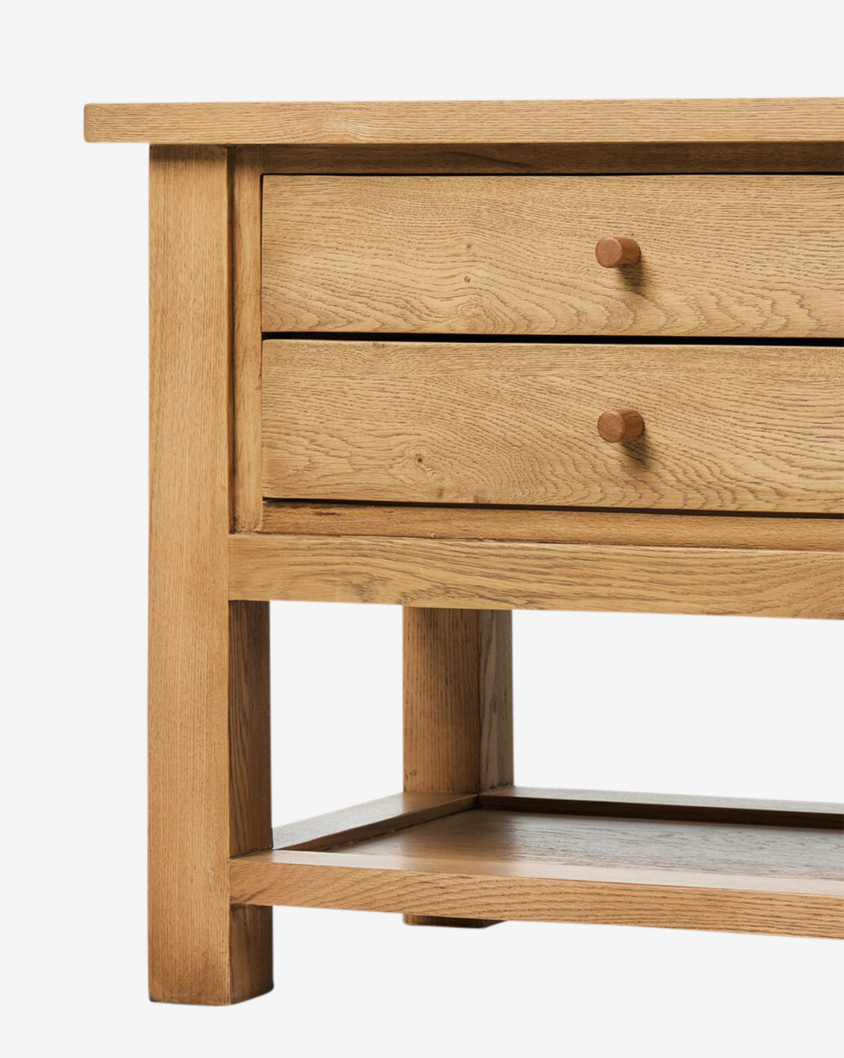 A close-up view of the Faelan Nightstand, featuring two drawers with round knobs and a lower shelf, crafted in light oak veneer—ideal for easy bedroom styling, by McGee & Co.