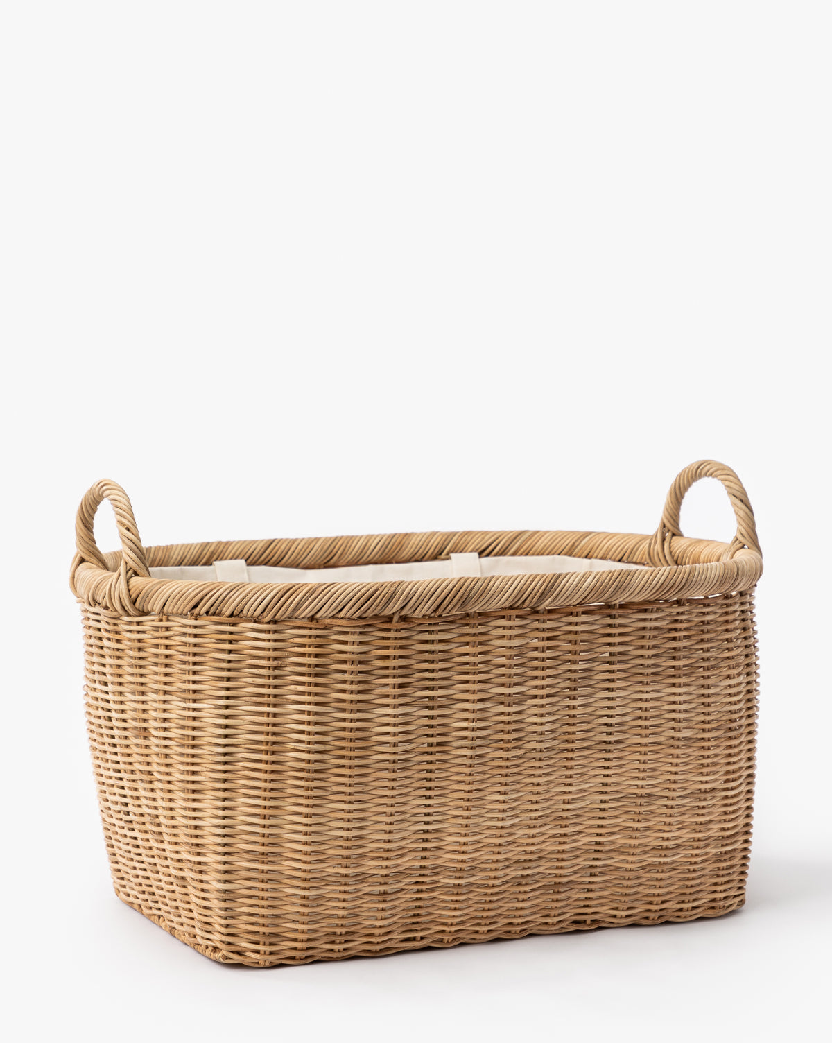 The Fairway Laundry Basket, a rectangular wicker basket with two side looped handles and a neat canvas lining, is displayed against a white background by McGee & Co.