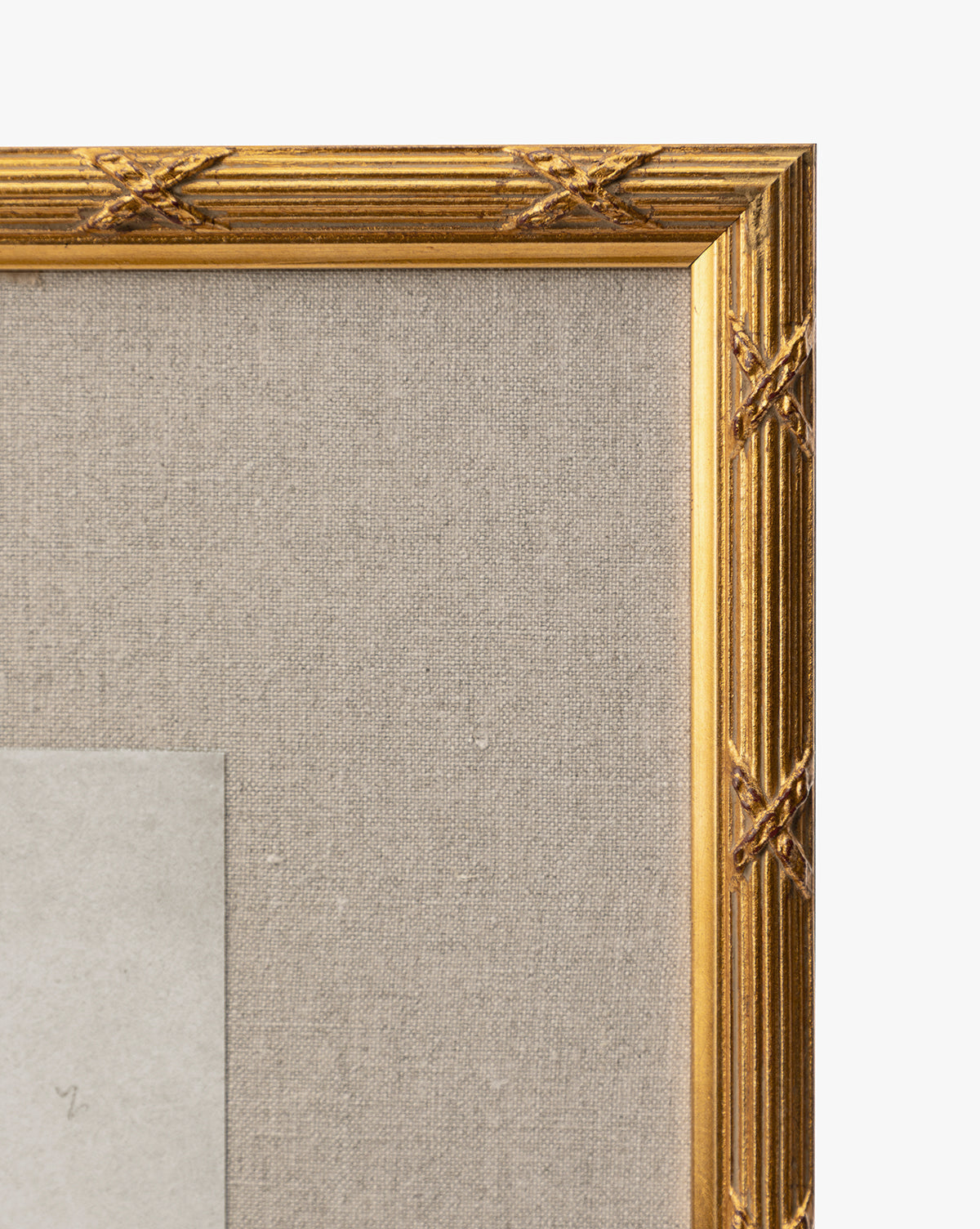 Close-up of the top right corner of the gold leaf frame with a textured beige fabric backing, showcasing part of the gray rectangular Feathery Floral giclée on paper within the frame by McGee & Co.