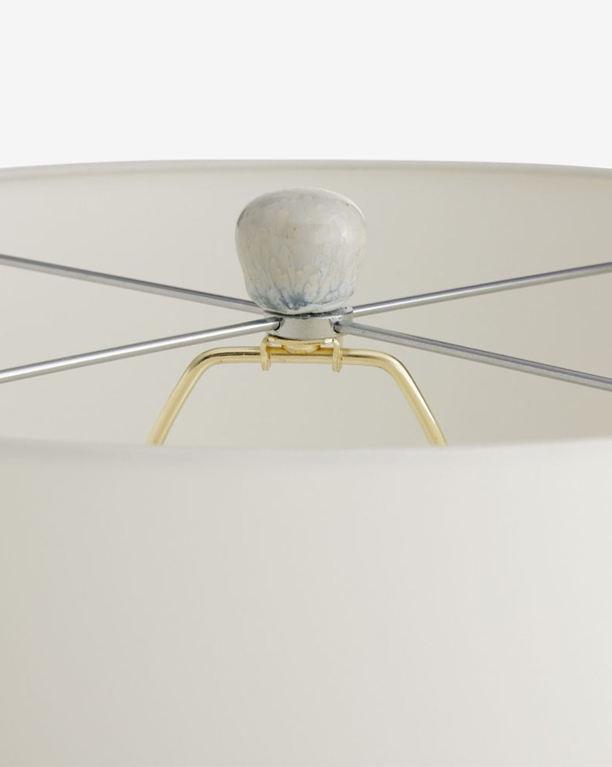 Close-up of the Fig Table Lamp’s shade top, showcasing a marbled ceramic finial, metal crossbars, and gold support structure inside the white shade—an elegant accent for home décor, by McGee & Co.