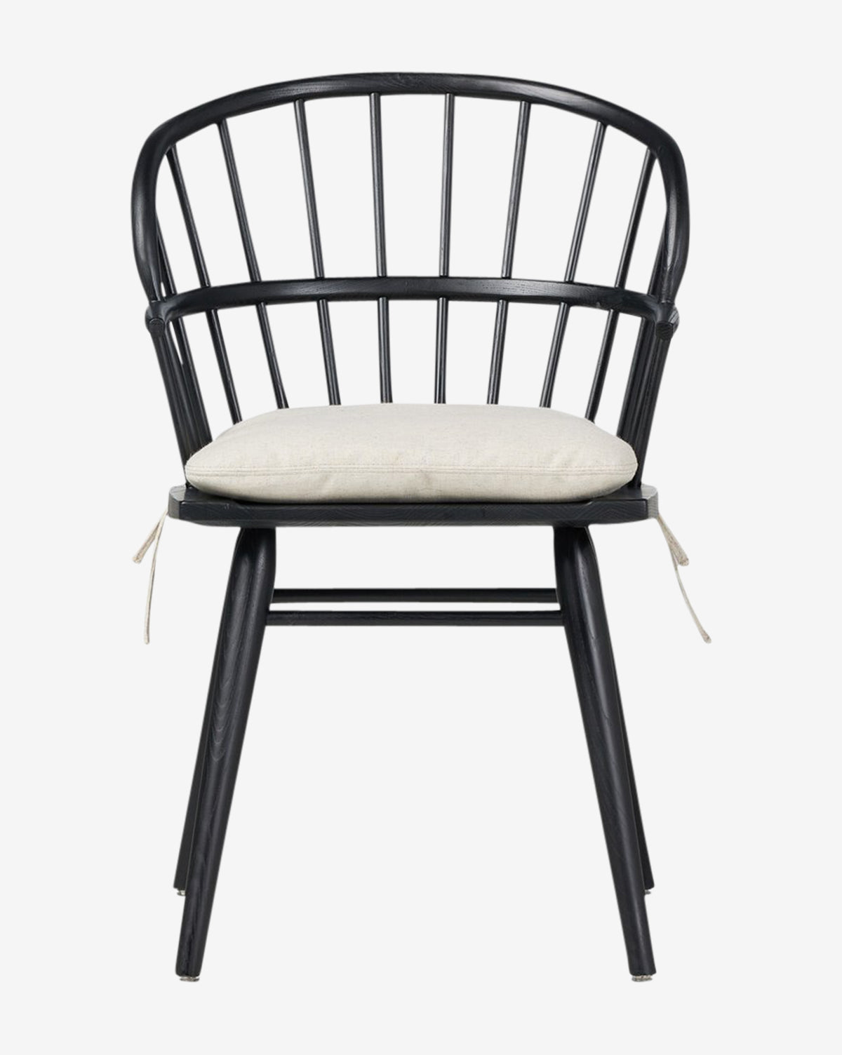 The Fiora Dining Chair is a black wooden chair with a curved spindle backrest and four legs, featuring a light beige removable cushion that ties to the seat—ideal for any dining space, by McGee & Co.