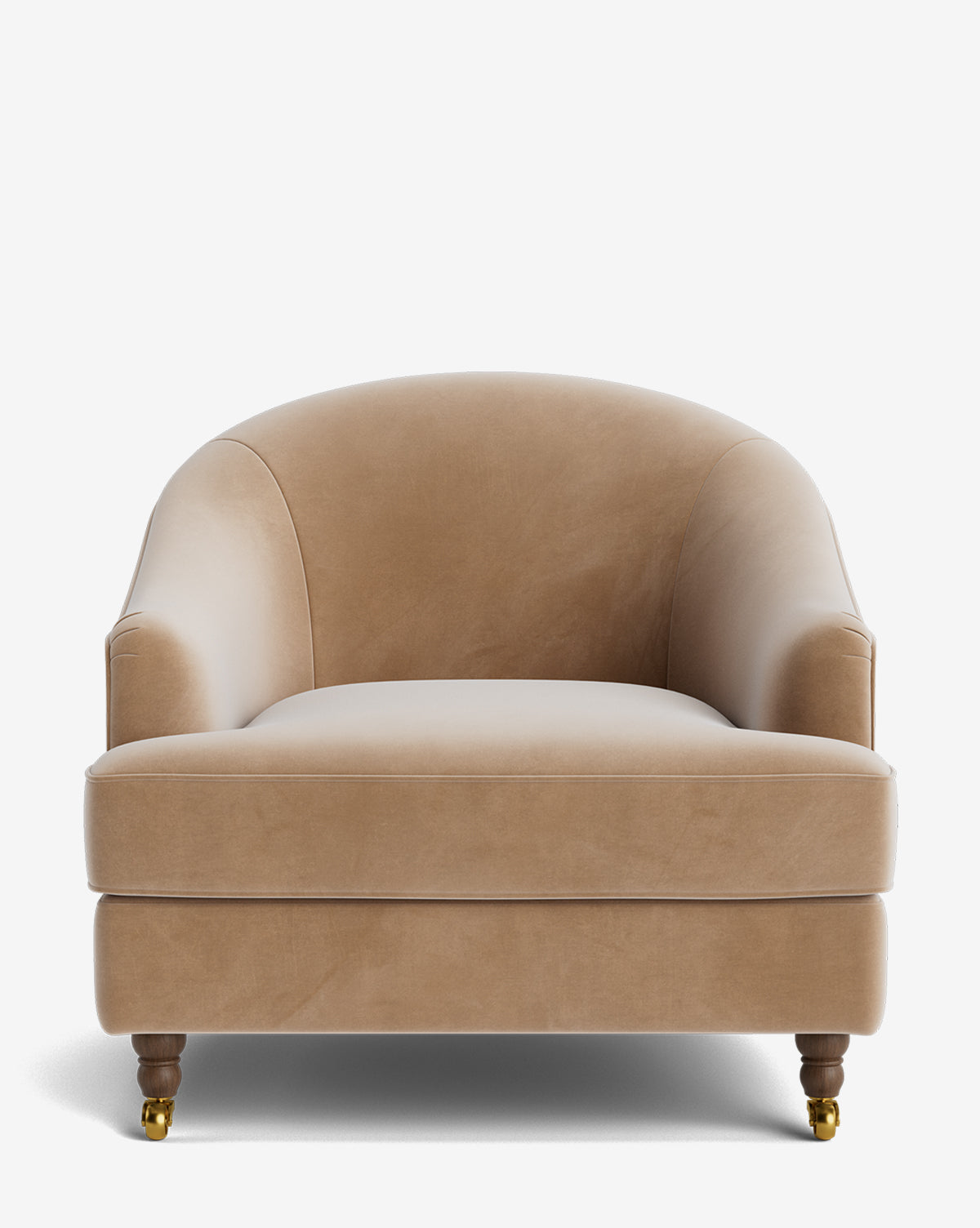 The Fletcher Lounge Chair features tan velvet upholstery, rounded arms and backrest, and wooden legs with brass casters. Shown front-facing on a white background, this handcrafted chair is also available in customizable fabrics by McGee & Co.
