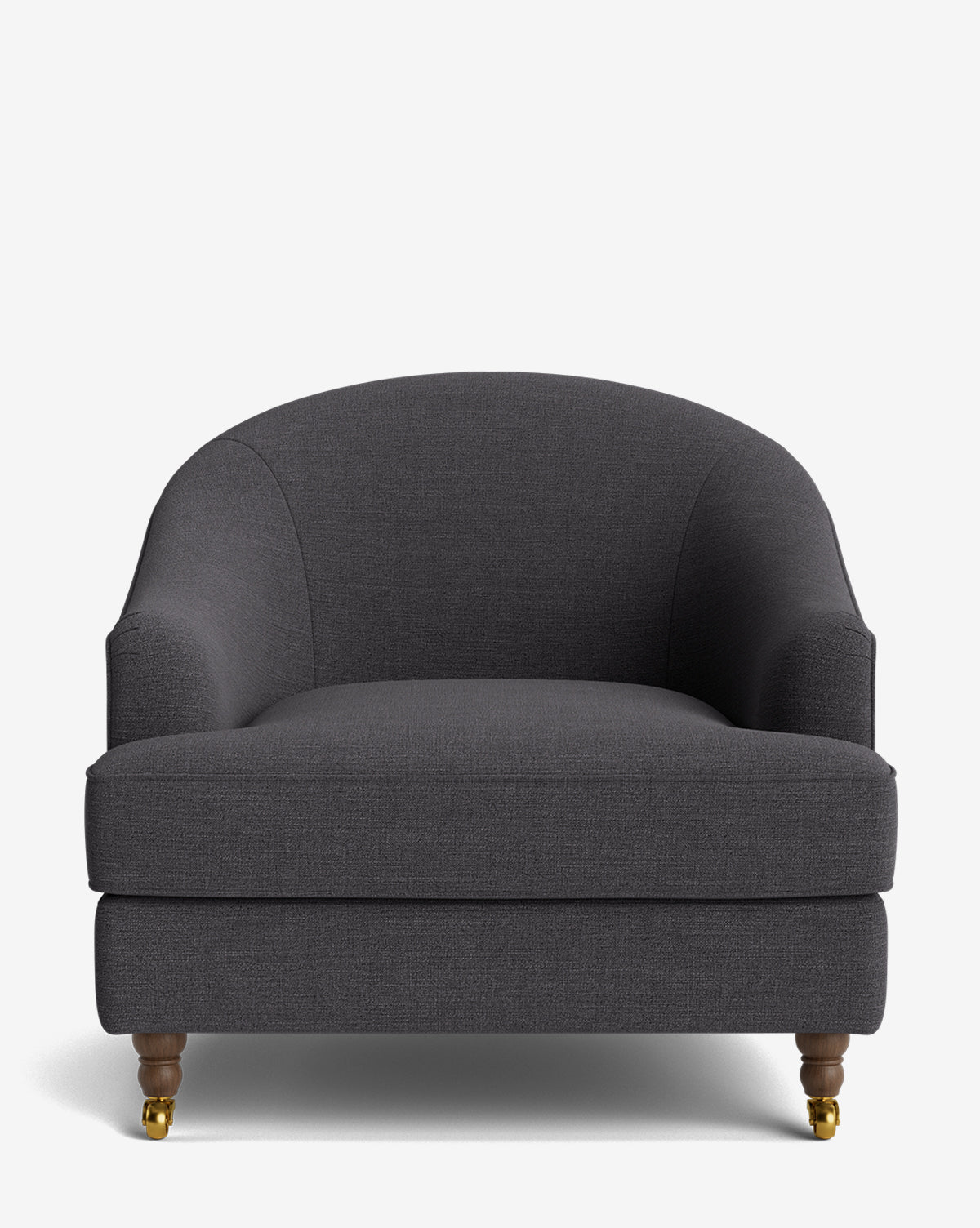 The Fletcher Lounge Chair features dark gray upholstery, a rounded backrest and arms, wooden legs, and brass casters on the front legs, by McGee & Co. Handcrafted for quality, its displayed against a plain white background.