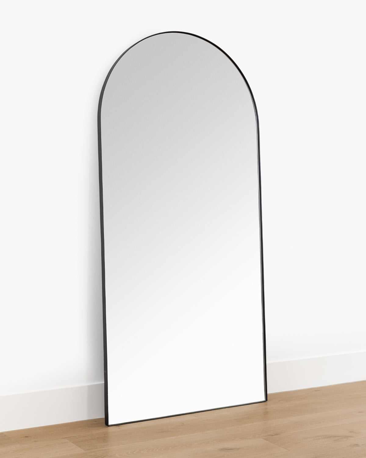 The Gala Floor Mirror features a slim black frame and leans stylishly against any wall, making it the perfect statement piece for your bedroom, by McGee & Co.
