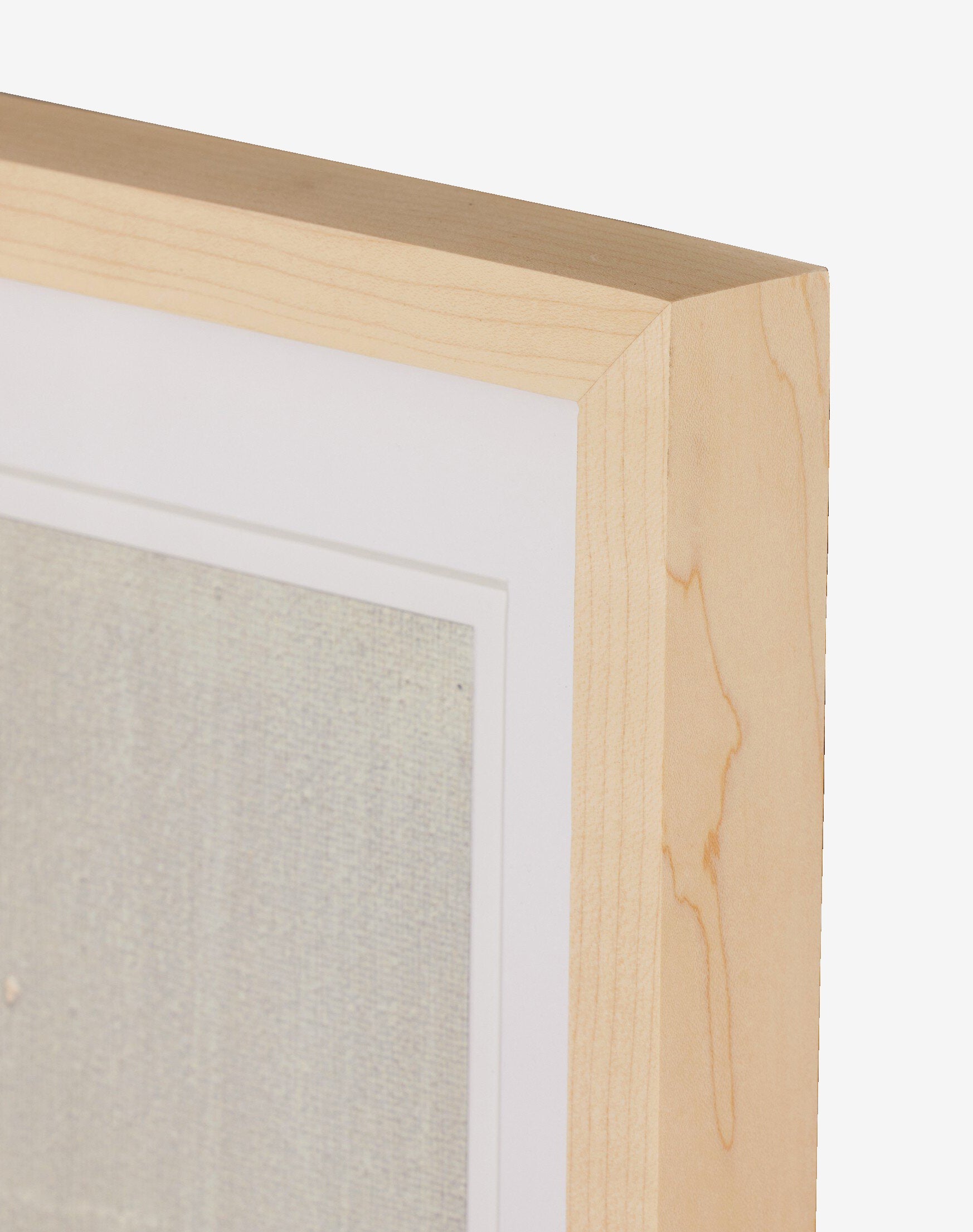 Close-up of the top right corner of a natural-toned frame with a white mat, showing part of Galactic V by Jade Dacay, a textured mixed media minimalist artwork, by McGee & Co. The background is plain white.