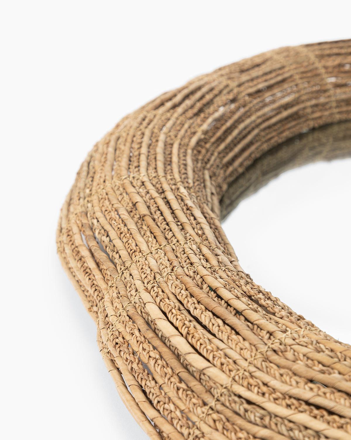 Close-up of the Gareth Woven Mirror, a circular mirror crafted from light brown rattan with a natural finish, set against a white background by McGee & Co.