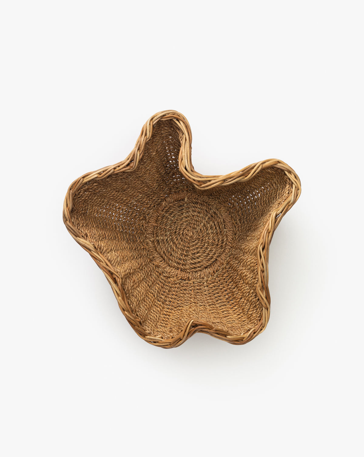 The Goulding Woven Bowl features an irregular, wavy-edged shape in natural wicker, making it a unique statement piece for entryway decor, by McGee & Co. Displayed against a plain white background.