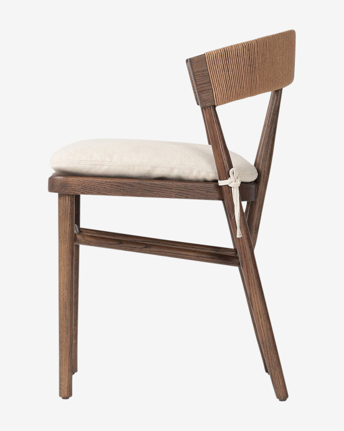 The Hallow Chair features a dark oak frame, angled backrest, beige tied cushion seat, and minimalist modern design for a sleek dining room look, by McGee & Co.