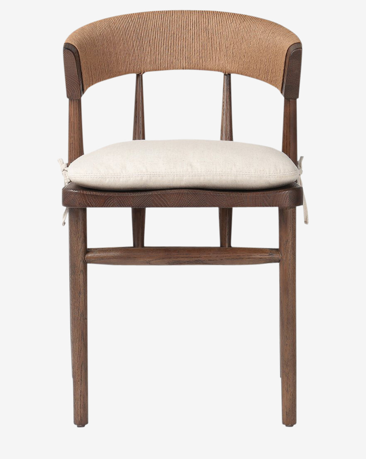 The Hallow Chair is a rustic dining chair featuring a curved backrest, tapered legs, and a light beige cushion tied to the seat, shown against a white background by McGee & Co.