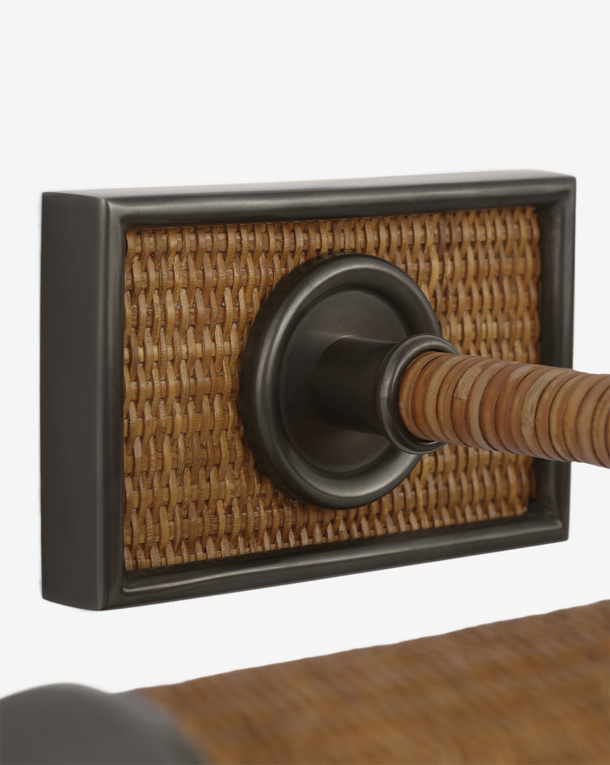 The Halwell Picture Light features a wall-mounted design with a rectangular backplate in a woven rattan pattern, a dark circular metallic accent, and a rattan-wrapped rod—perfect for illuminating your artwork in style, by McGee & Co.