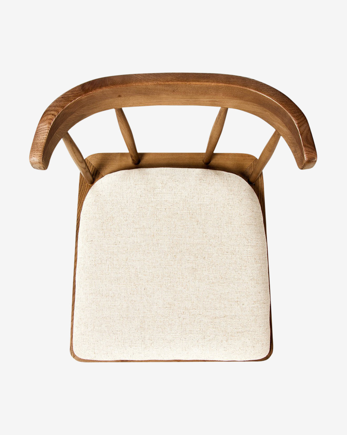Top view of the Harper Dining Chair featuring a curved backrest and light beige upholstered seat cushion, made from solid ash wood, displayed against a plain white background, by McGee & Co.