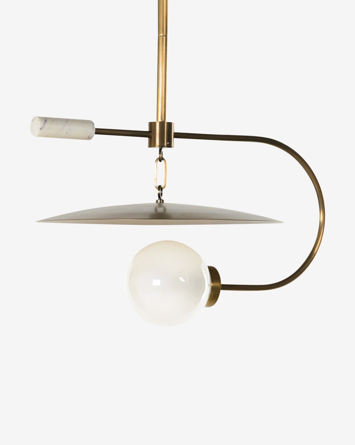 The Harpo Pendant showcases a modern look with an antique brass curved arm, white globe bulb, flat circular shade, and a standout white marble accent on top, displayed against a plain white background by McGee & Co.