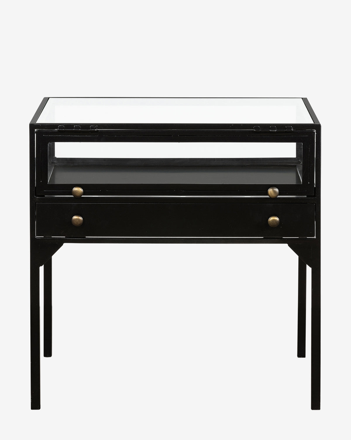 The Harry Nightstand boasts a modern minimalist style with a black metal frame, glass top, open shelf, and single drawer accented by two round brass knobs. Four straight legs complete its sleek brass-accented design.