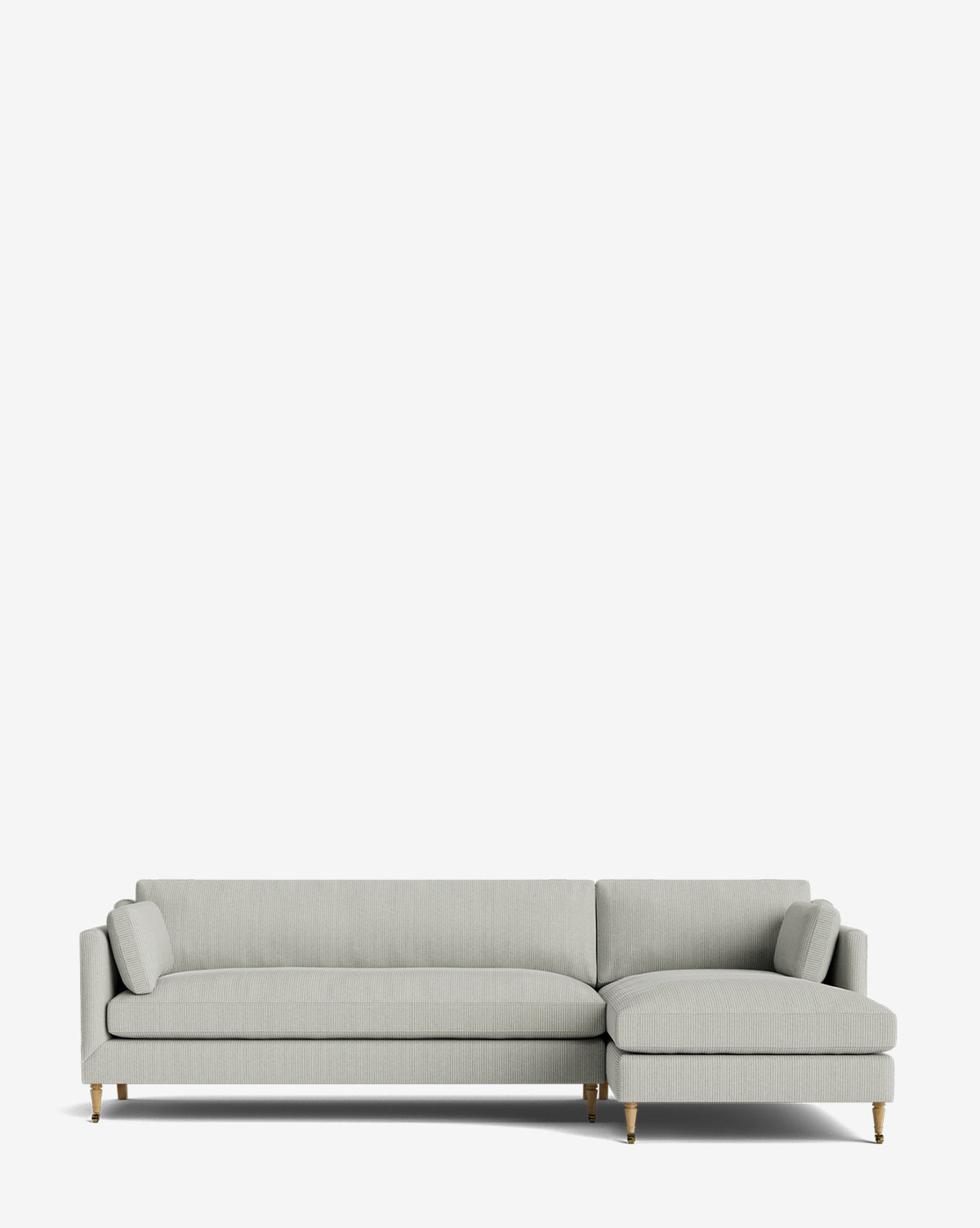 Light gray Haverford Upholstered Right Chaise Sectional 113 with a low backrest, two matching bolster pillows, and wooden legs with brass accents, shown against a plain white background by McGee & Co.