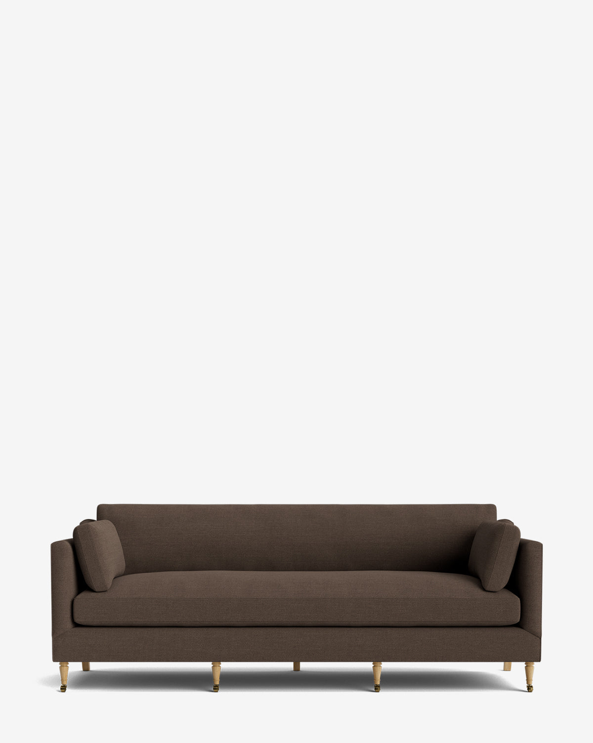 The Haverford Upholstered Sofa 90 features a modern design with clean lines, dark brown upholstery, slim armrests, cylindrical bolster pillows, and slender gold legs, making it a standout piece against a white background, by McGee & Co.